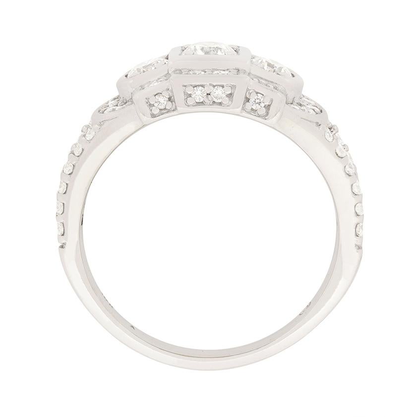 This vintage diamond ring is made in a style reminiscent of the art deco era. The centre diamond is 0.25 carat, while the diamonds to either side are 0.20 carat each. An additional 0.85 carat of round brilliant cut diamonds surround the centre three