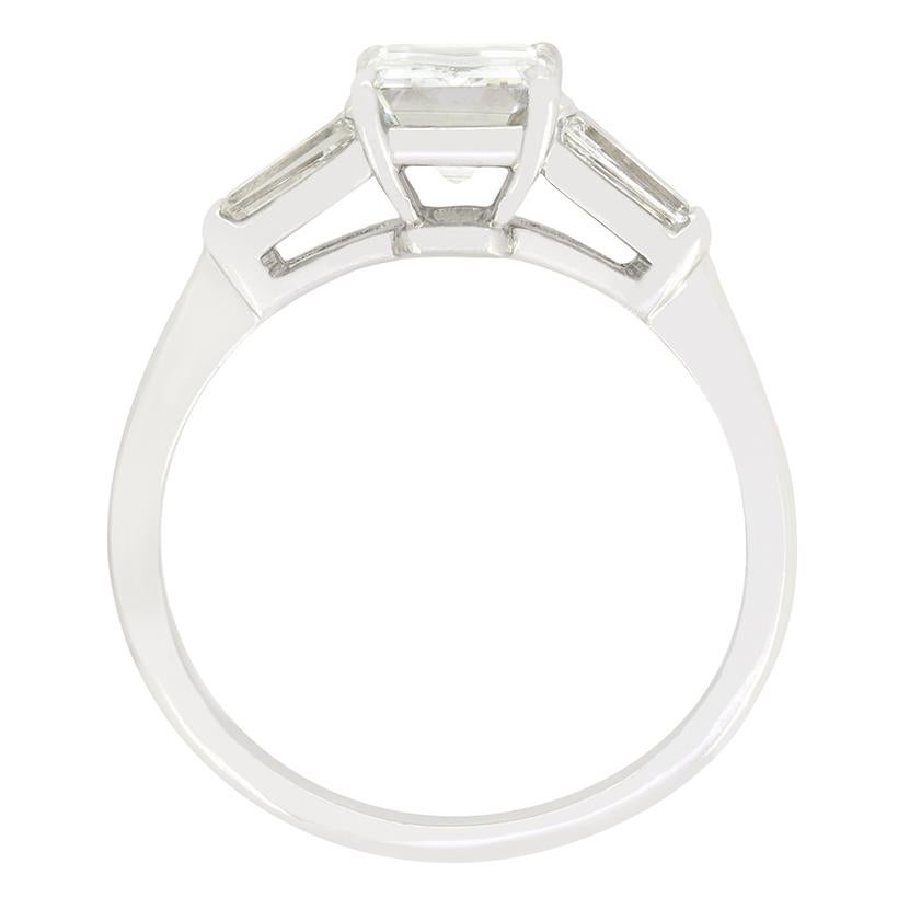 This stunning Vintage solitaire ring features a beautiful 1.55 carat emerald cut diamond at it’s centre. The diamond is of excellent quality and comes fully certified by GIA, with a colour of D and clarity of SI1. Accenting the centre stone, two