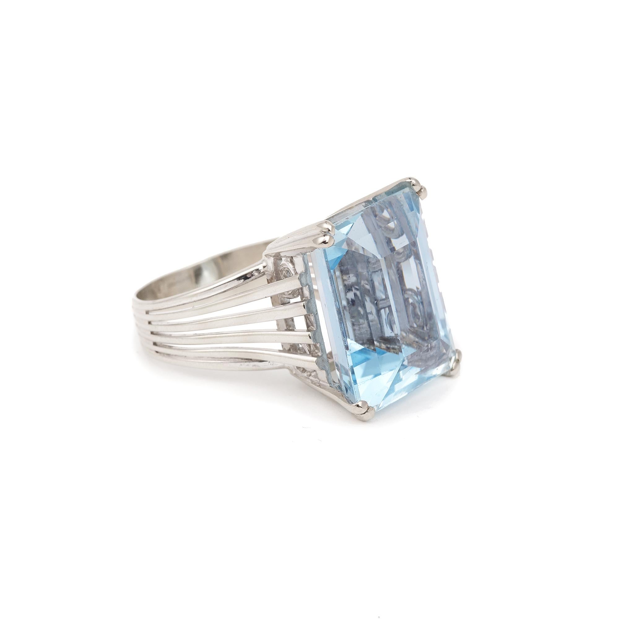 Vintage white gold ring set with a large faceted aquamarine in a emerald cut rectangular shape sides in claw setting.

Weight of the aquamarine: about 16 carats (the gemstone being set).

Dimensions of the ring 19.2 × 16 × 12 mm / 0,76 X 0,63 X 0,47