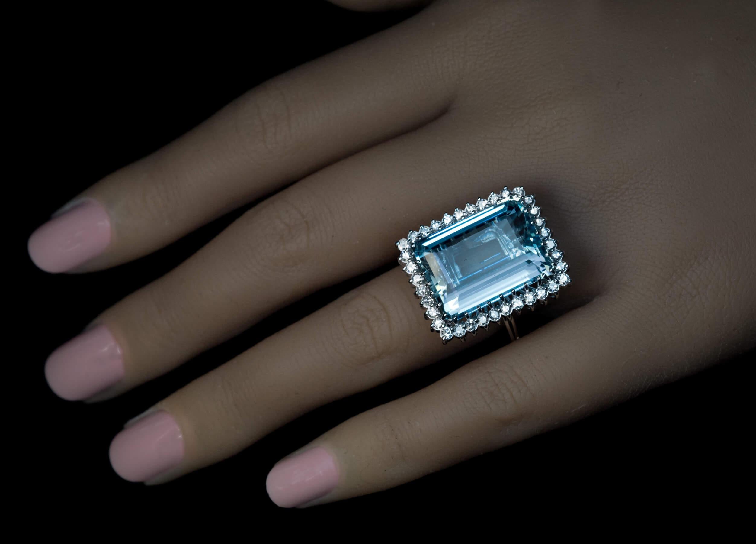 Circa 1970  The 14K white gold ring features a large aquamarine of a cool light blue color framed by single cut diamonds.  The aquamarine measures 18.98 x 14.01 x 8.81 mm and is approximately 16.05 carats.  Estimated total diamond weight is 1.05