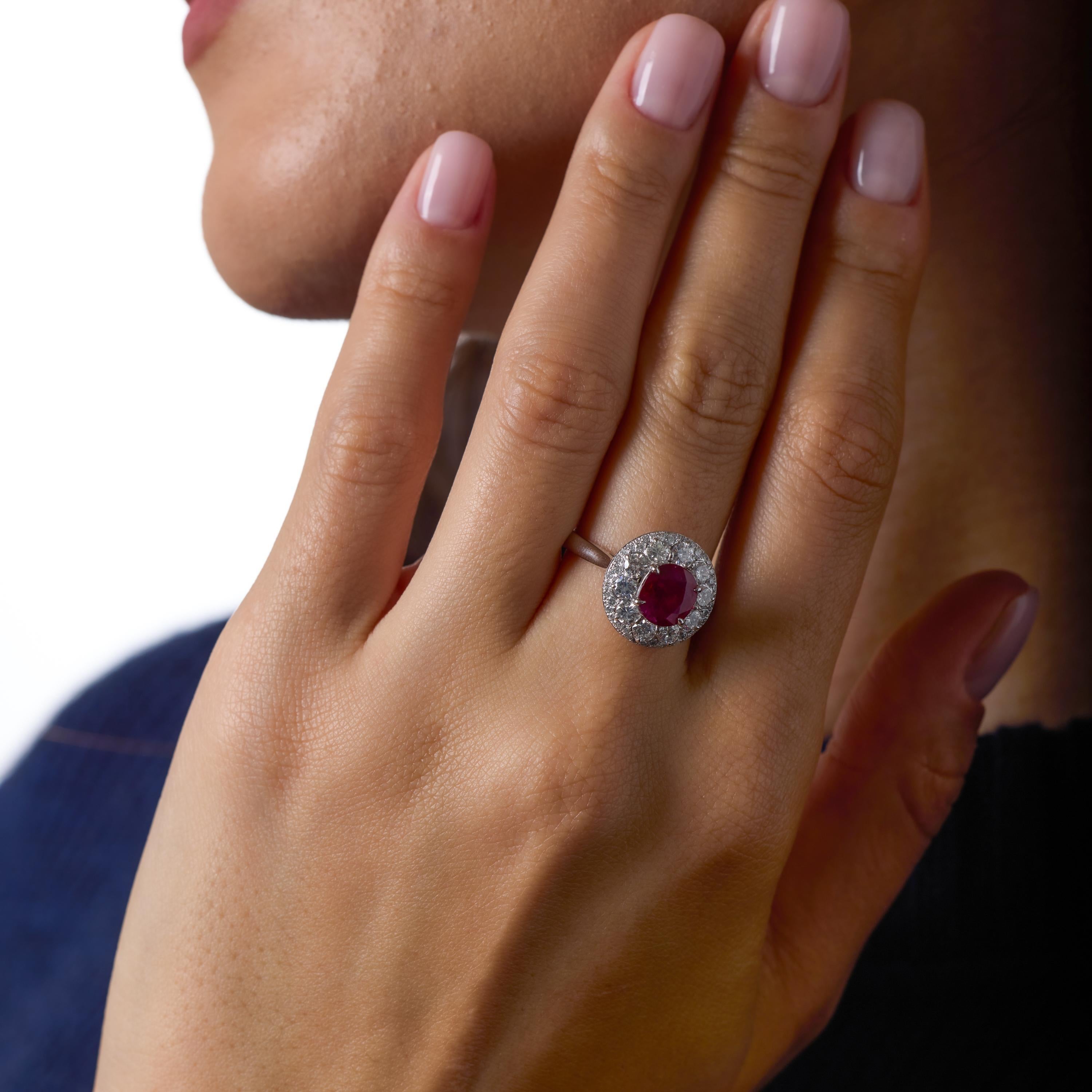 Dieser Vintage-Ring aus Platin zeigt einen leuchtenden Rubin von 1,61 Karat in der Mitte, umgeben von einem eleganten, reichlich funkelnden Halo aus klaren Diamanten der Farbe F und Reinheit VS. Das dynamische Zusammenspiel zwischen dem satten Rot