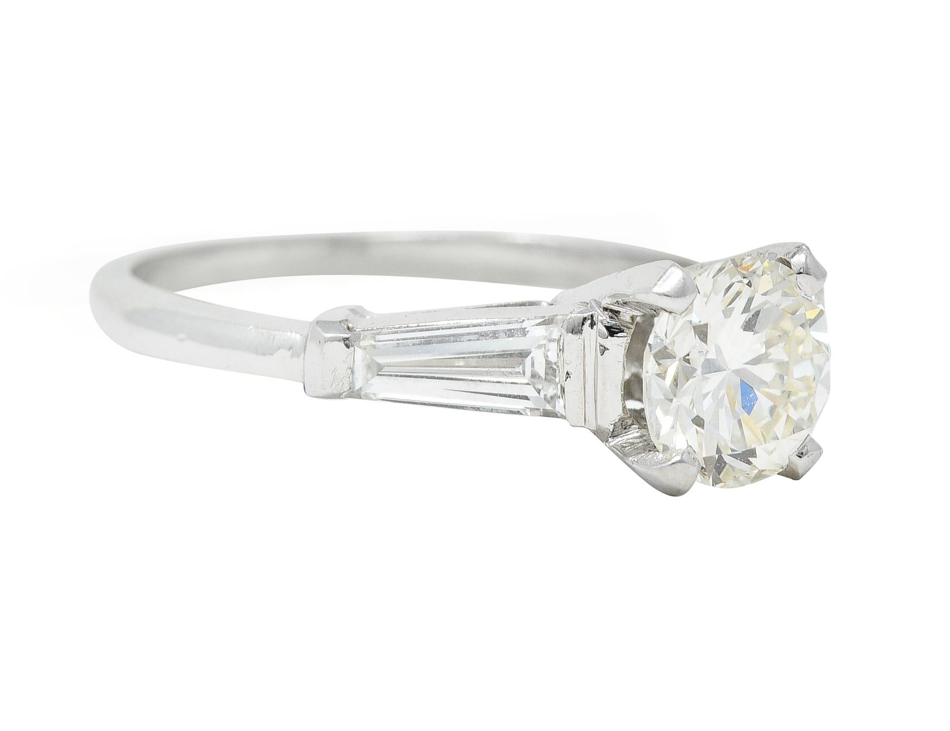 Centering an old European cut diamond weighing 1.07 carats - L color with VS2 clarity
Prong set in a basket and flanked by tapered baguette-cut diamonds
Weighing approximately 0.54 carat total - well matched to center
Bar set in cathedral style