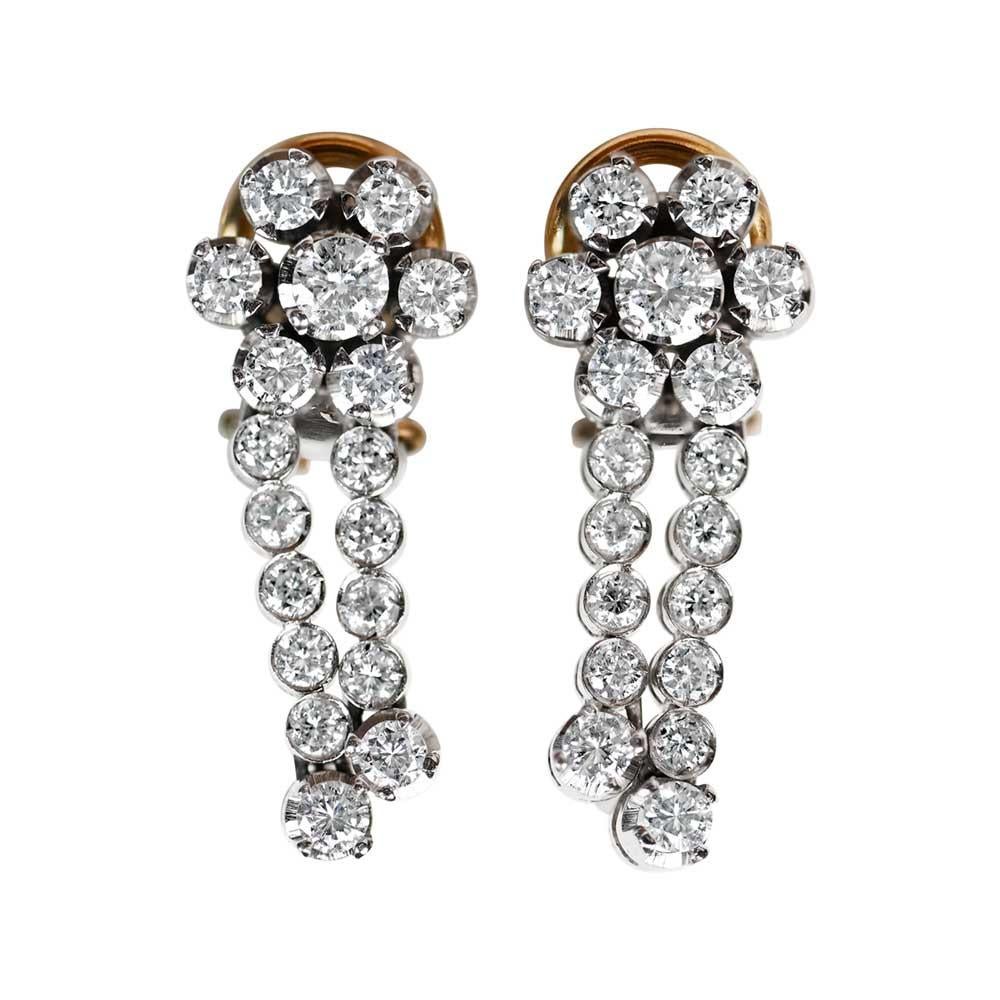 Adorn yourself with vintage allure through these earrings, showcasing a captivating floral arrangement of transitional cut diamonds. The top section boasts diamond clusters securely set in prongs, while below, two rows of diamonds gracefully sway,
