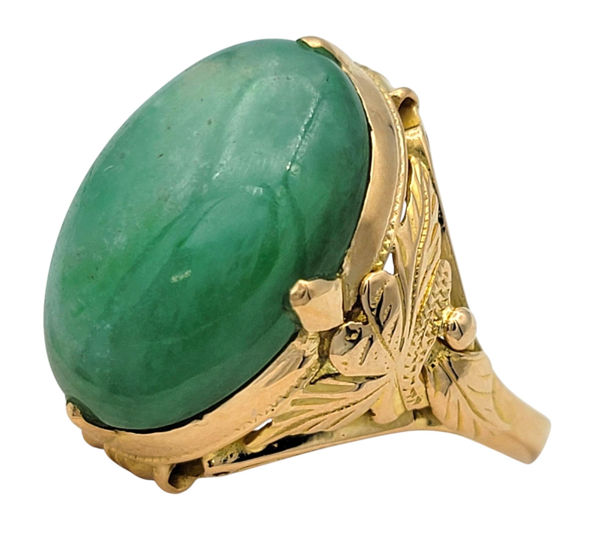 Ring Size: 7.5

This captivating vintage ring features a mesmerizing oval cabochon-cut jadeite in a vibrant green hue, exuding an air of timeless sophistication. The smooth, polished surface of the jadeite enhances its luster, creating a serene yet