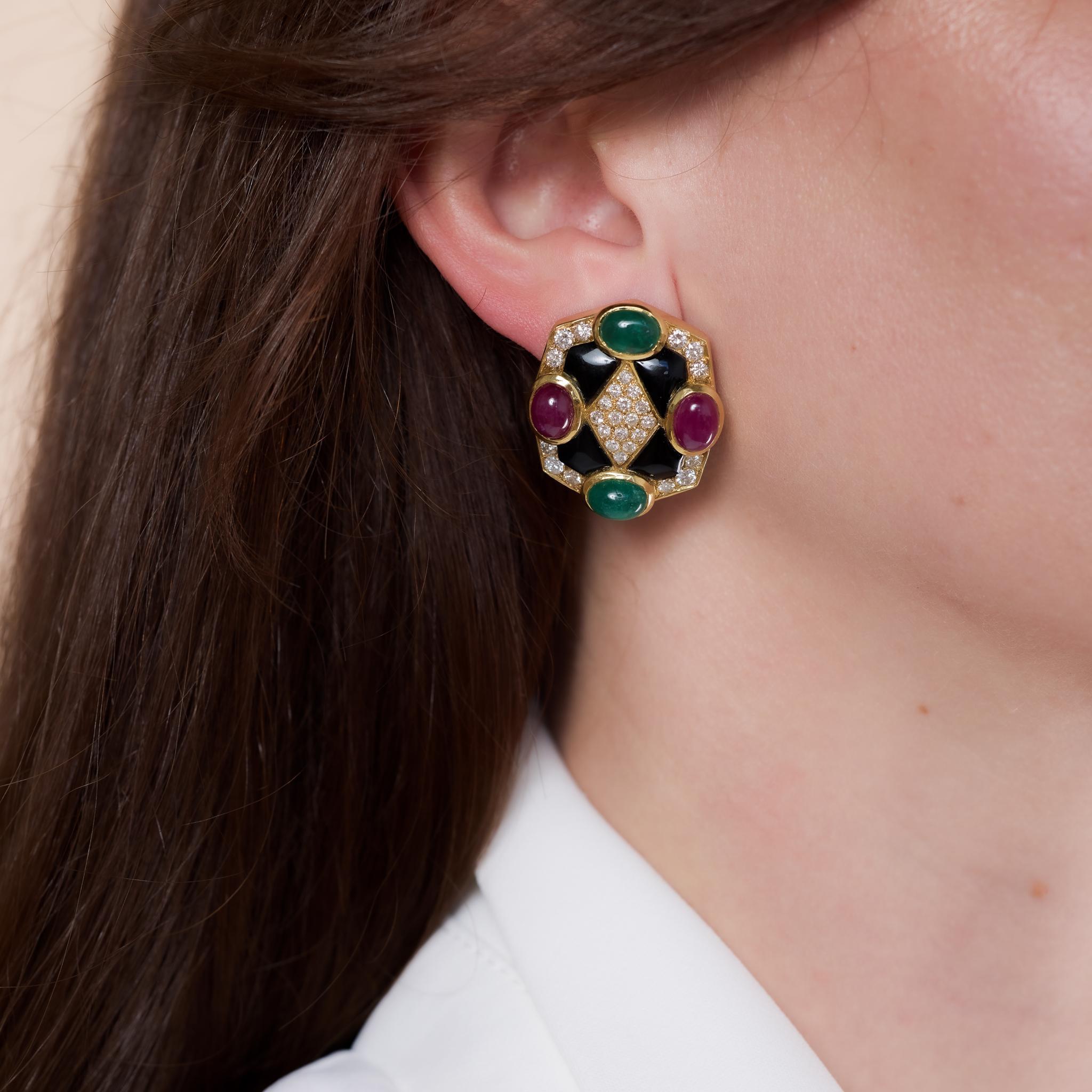 Vintage 18k yellow gold clip-on earrings set with 16.90 carats of rubies, emeralds, onyx, and diamonds, offering a bold yet elegant statement, circa 1980s.

Total gemstone weight: Approximately 16.90 carats
Center stone: 4 cabochon cut rubies