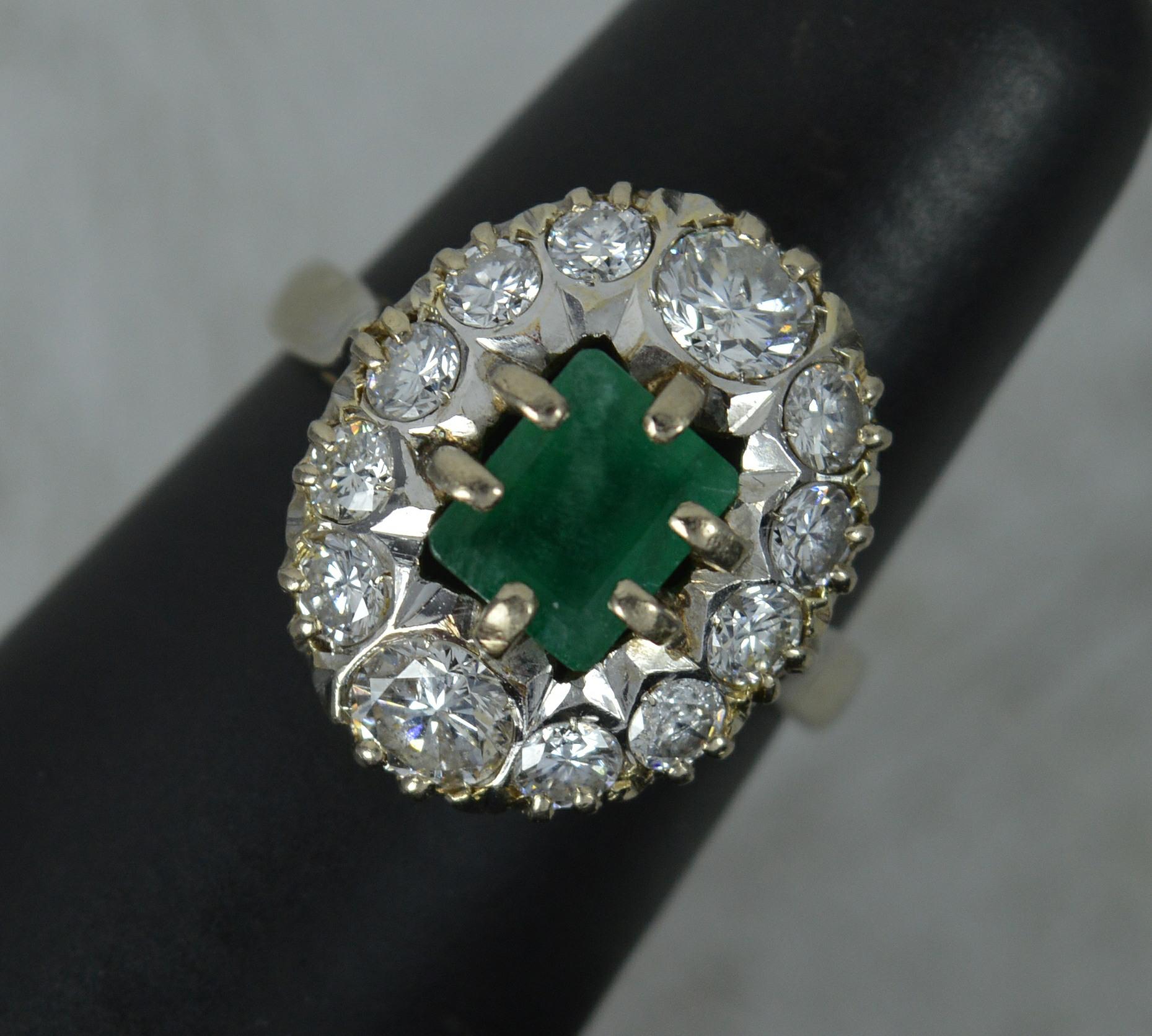A stunning Emerald and Diamond cluster ring.
Modelled in 18 carat gold throughout.
Designed with a natural emerald to centre, emerald cut, 5.5mm x 6.8mm approx. Surrounding are twelve natural round brilliant cut diamonds to total 1.6 carat. Clean
