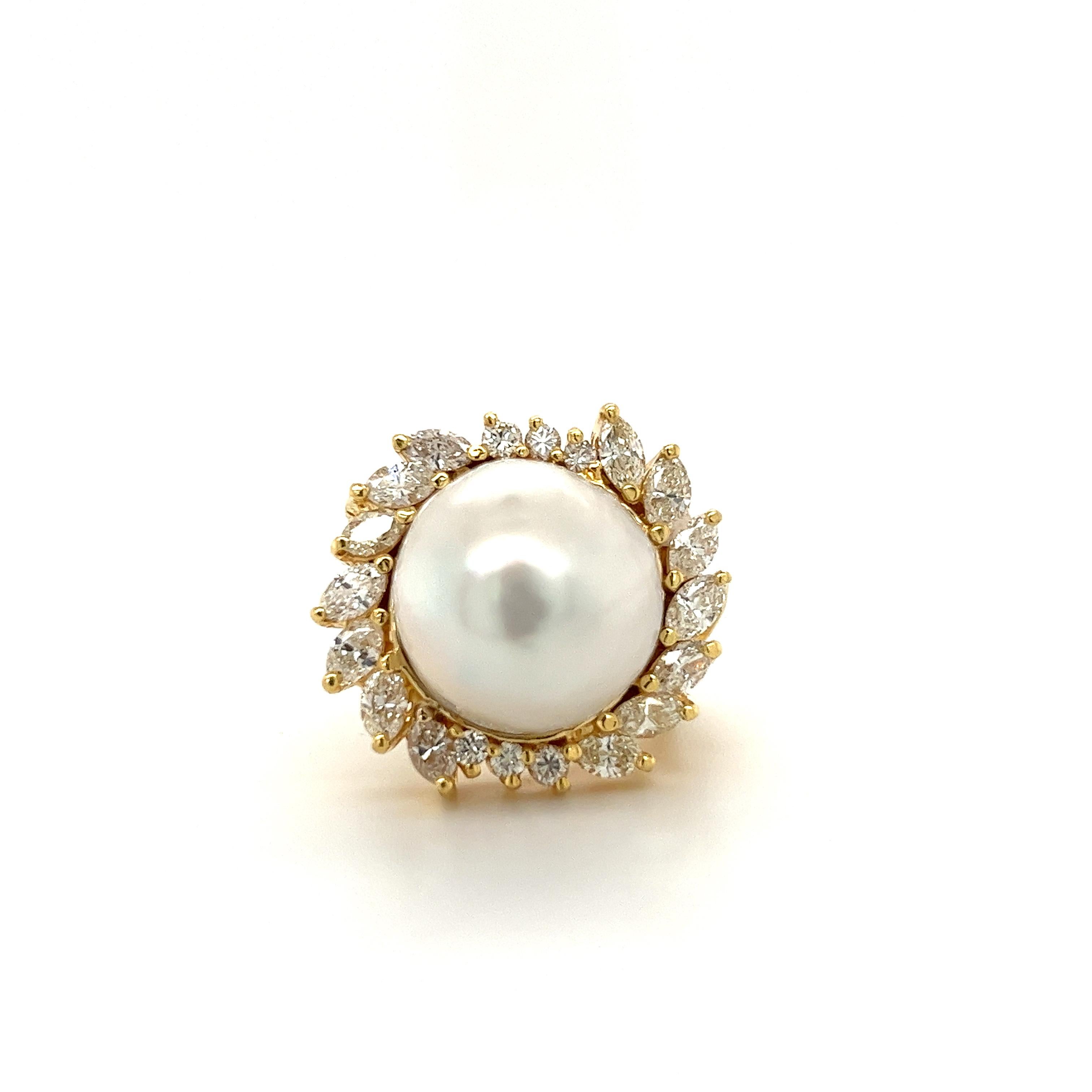 Vintage pearl and diamond ring set in 18 karat solid yellow gold. The pearl is set with over 3 carats in marquise and round-cut diamond halo. This South Sea Pearl bears a vibrant white luster with little to no blemishes. The perfect heirloom piece