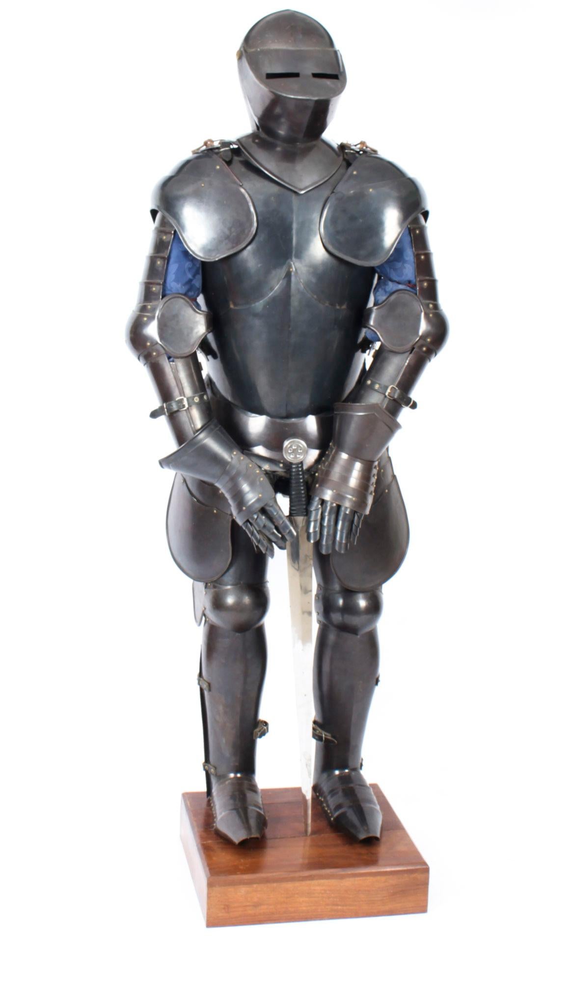 This is a fabulous hand crafted complete suit of 16th century style armour dating from the second half of the 20th century.

The fully articulated suit is mounted on a wooden stand complete with a two handed double edged sword. 

This is an