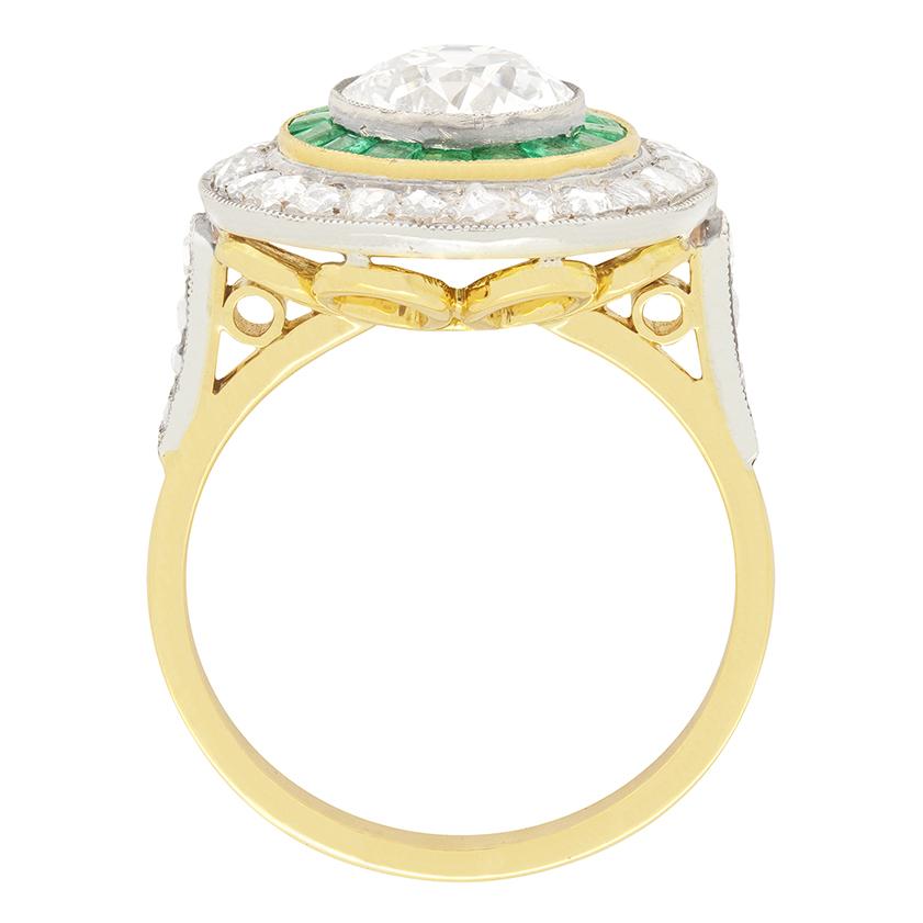 This fascinating target ring features a 1.70 carat old European cut diamond to the centre which is then encircled by a row of square cut natural emeralds creating a superb contrast and ending with an outer halo of shimmering rose cut diamonds. There