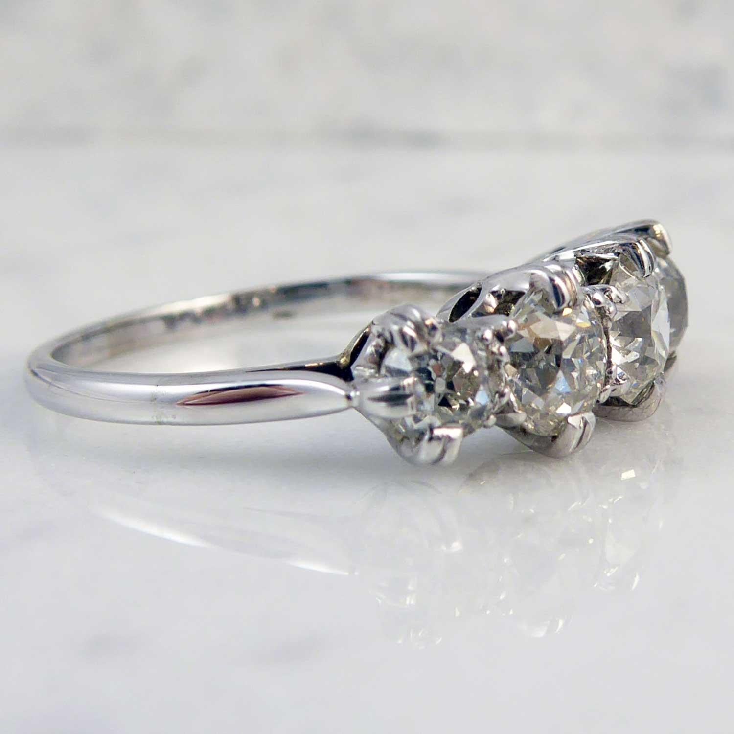 A vintage diamond ring set with a total of five old European cut diamonds in a row across the finger.  The diamonds are all claw set in white metal and graduate in size from the centre diamond at 4.85mm  x 4.78mm down to 3.67mm x 3.47mm.  White