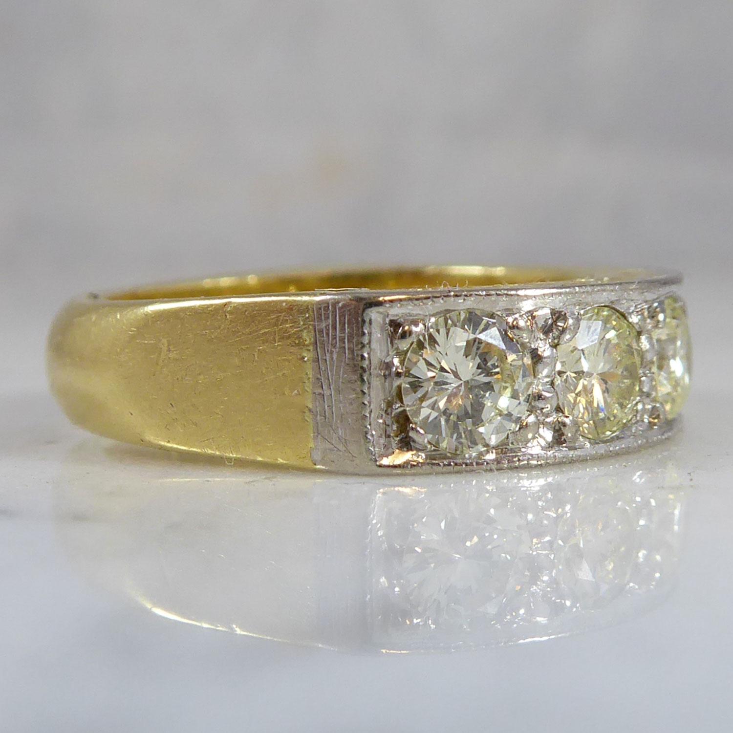 A fabulous seven stone diamond ring set with uniformly round brilliant cut diamonds, measuring approx. 4.20mm diameter, grain set to a white mille grain border and with yellow scroll engraved gallery.  Plain shoulders to a D shaped cross sectioned