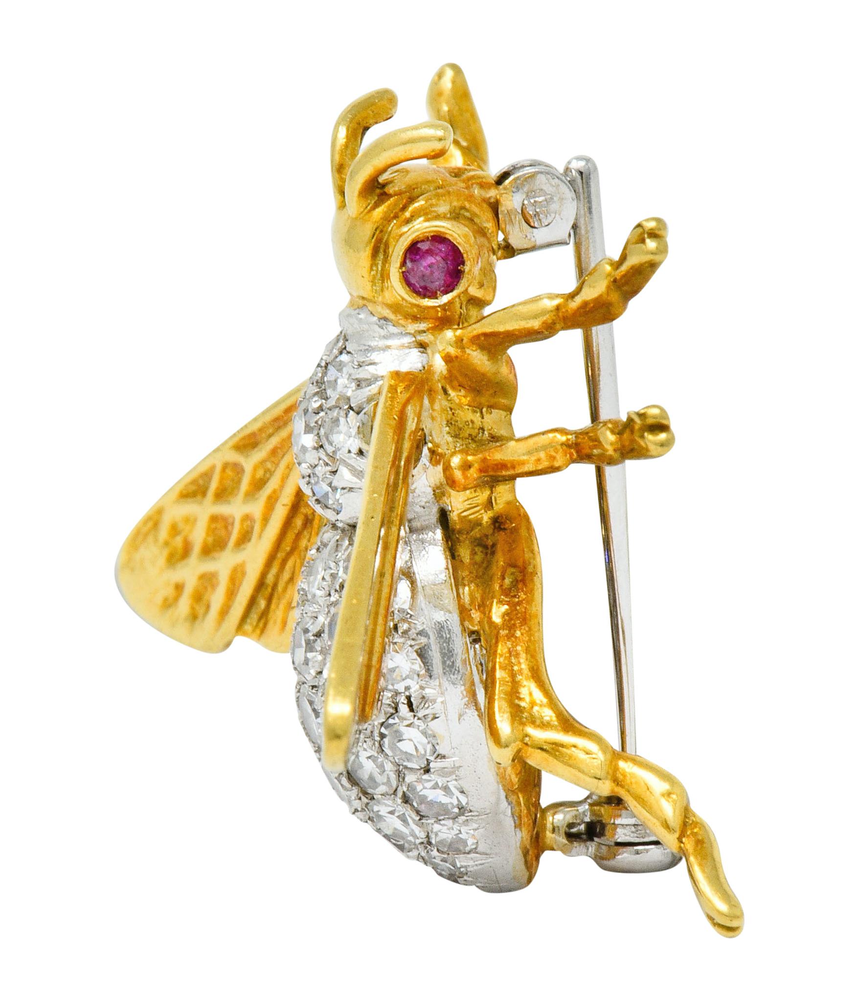 Brooch designed as a buzzing bee with bright gold wings and segmented legs, highly detailed

With gold head and antenna accented by round cut ruby, bezel set as eyes, weighing approximately 0.18 carat total; well-matched light red

Thorax and
