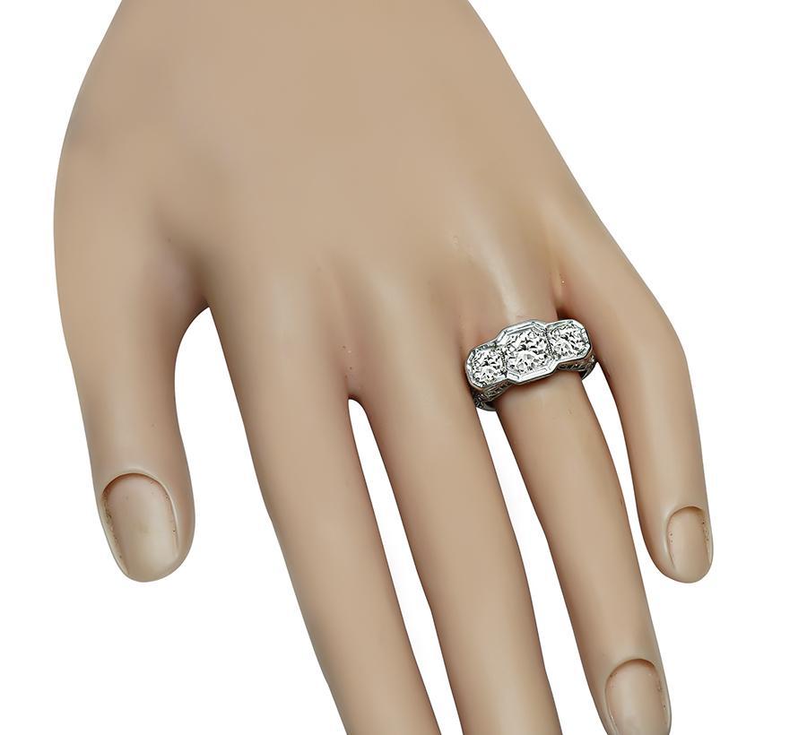 This is a stunning 18k white gold ring from the Edwardian era. The ring is centered with sparkling old mine cut diamond that weighs approximately 0.85ct. The color of the diamond is G-H with SI1 clarity. The center diamond is accentuated by 2