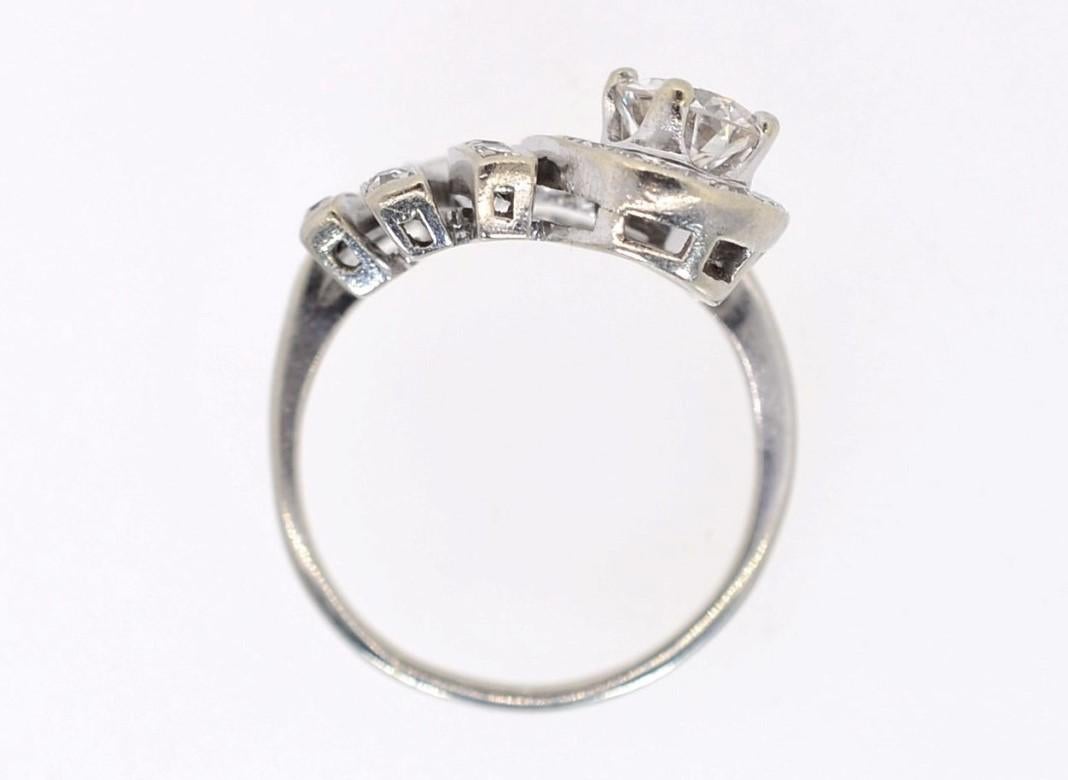 The 1950s feather tiara-style ring is created in 14KT white gold.  At its crest, a 0.65 carat Transitional cut Diamond brilliantly glows. The ring is set with a medley of Old Mine and Single cut Diamonds. All diamonds weigh approx. 1.78 carat of