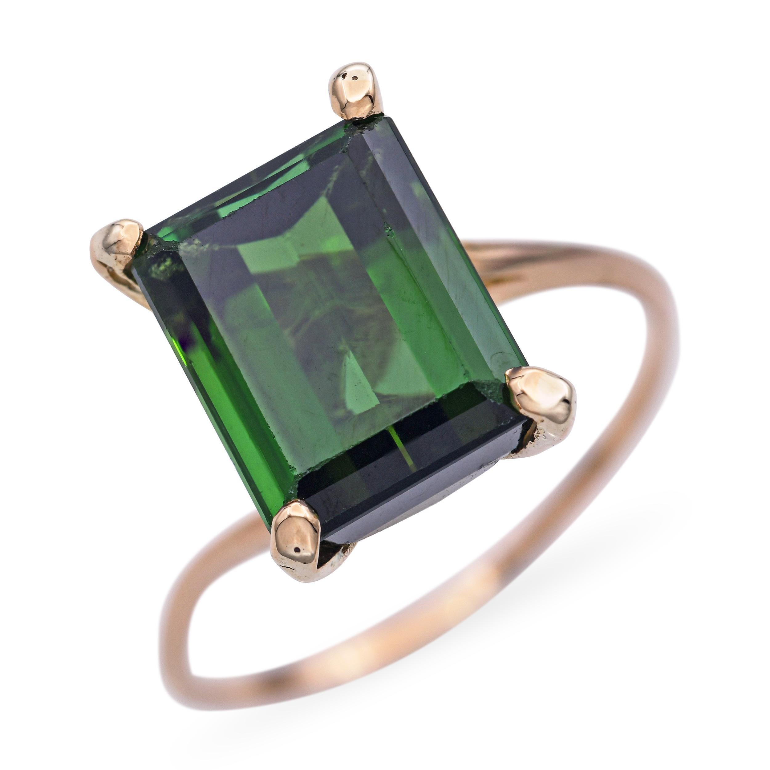 Cette bague vintage remarquable met en valeur une tourmaline verte de 4,75 carats sertie dans un riche or jaune de 17 carats - une combinaison rare et luxueuse. La teinte verte et profonde de la tourmaline est magnifiquement complétée par la monture