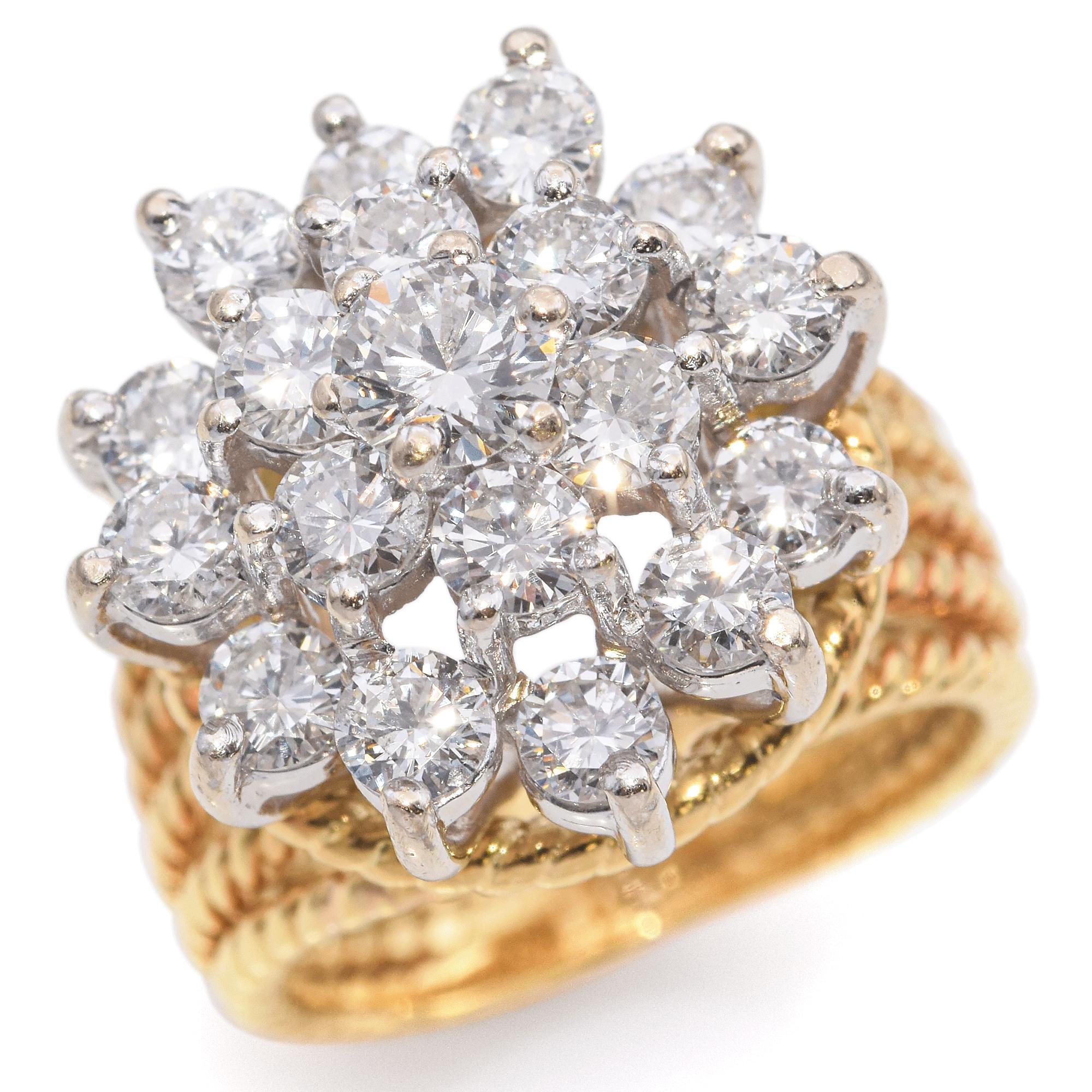 A stunning ring showcasing a dazzling array of diamonds.
Crafted in yellow gold, this exquisite piece features a cluster of brilliant round diamonds arranged in a captivating floral pattern. The diamonds catch the light beautifully, creating a