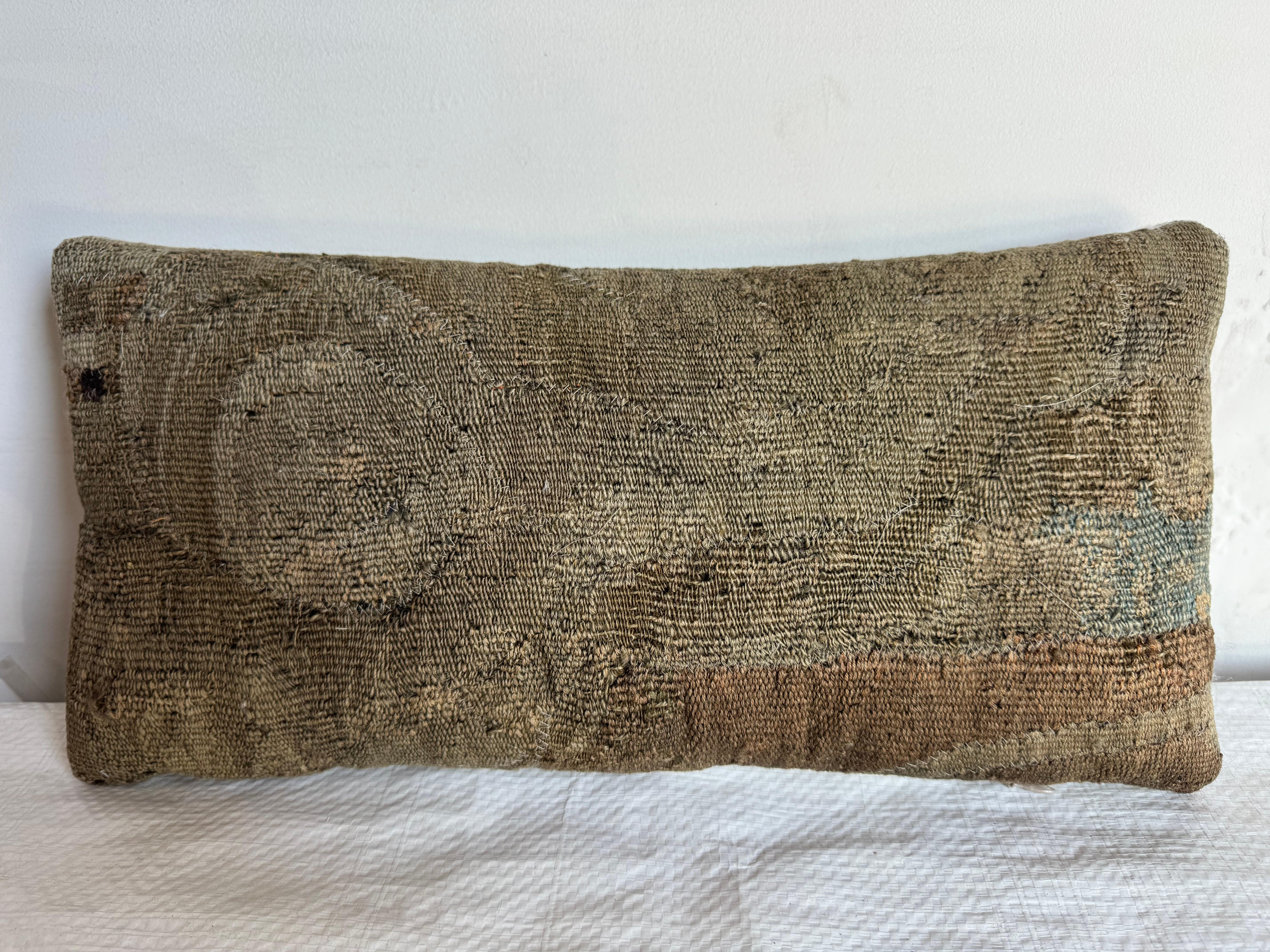 Dieses Vintage-Kissen ist ein Meisterwerk der Textilkunst und zeigt ein flämisches Wandteppichmuster aus dem 17. Die reichhaltigen botanischen Muster in warmen Farbtönen spiegeln eine tiefe Verbundenheit mit der Natur und der Tradition wider.

Mit