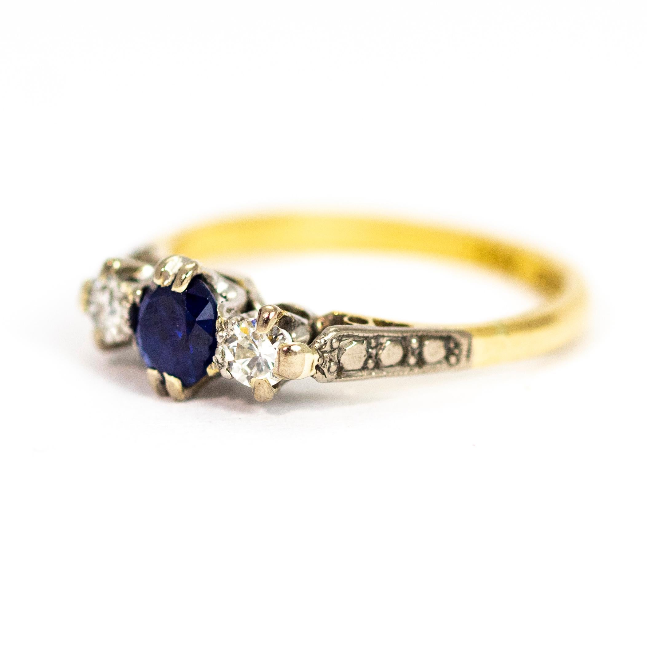 A superb vintage three-stone ring. The beautiful central blue sapphire measures 40 points and is flanked either side by stunning 15 point white diamonds. The stones are set in platinum between wonderful platinum studded shoulders. The band and is