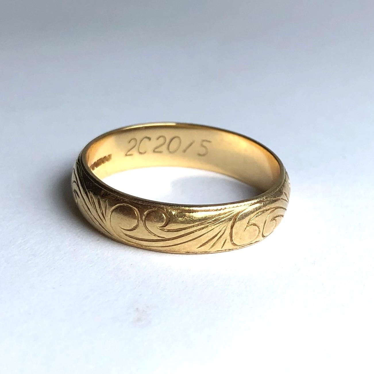 Das 18-karätige Goldband ist mit einer feinen Schnörkelgravur versehen, die auf beiden Seiten des Bandes von einer feinen Linie eingerahmt wird. 

Ringgröße: P 1/2 oder 7 3/4
Bandbreite: 5mm 

Gewicht: 4,5 g