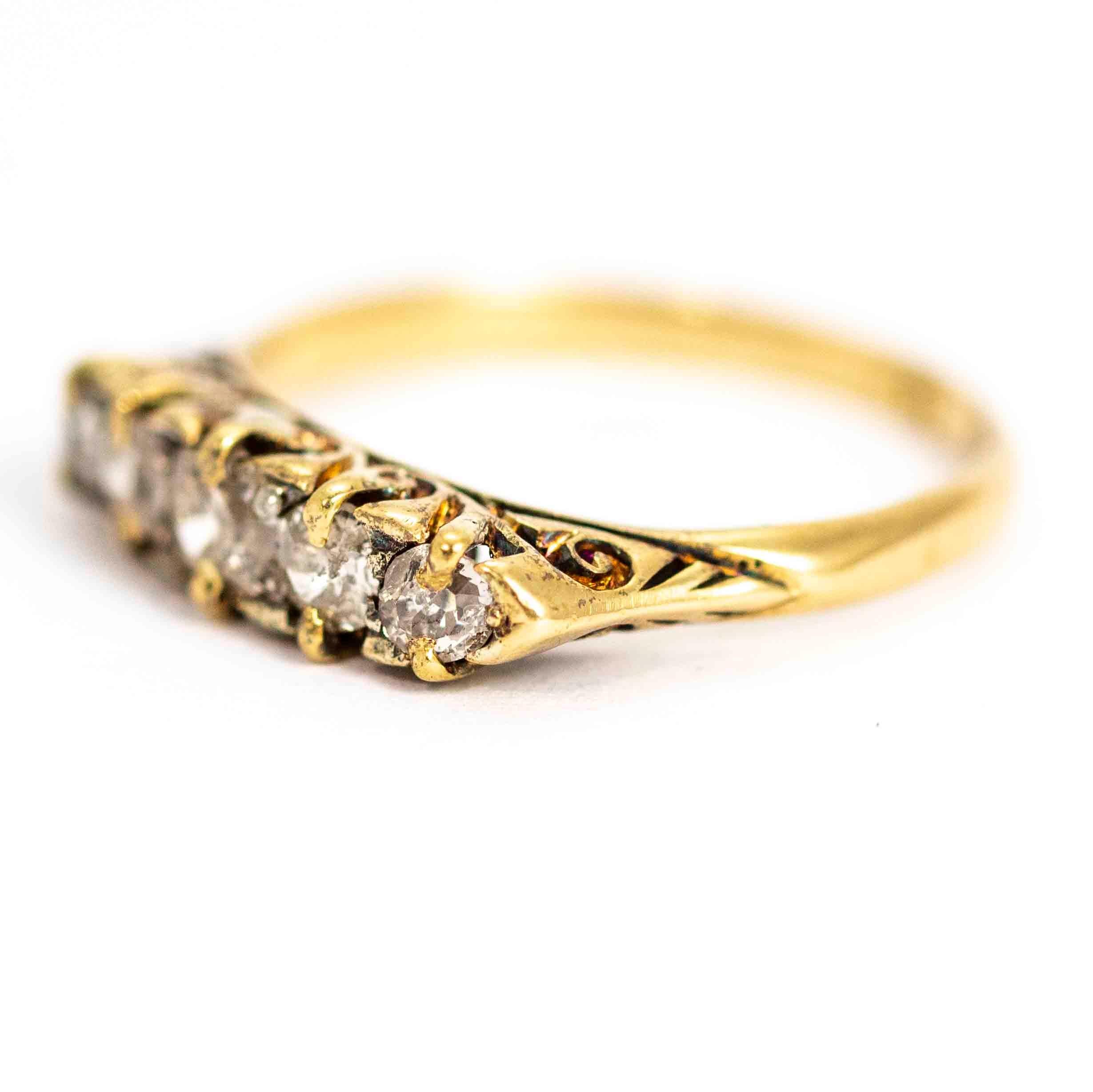 A stunning vintage five-stone ring set with diamonds. The central stone measures approximately 25 points. The total diamond weight in this ring is approximately 61 points. The stones are set in a beautiful classically ornate gallery. Modelled in 18