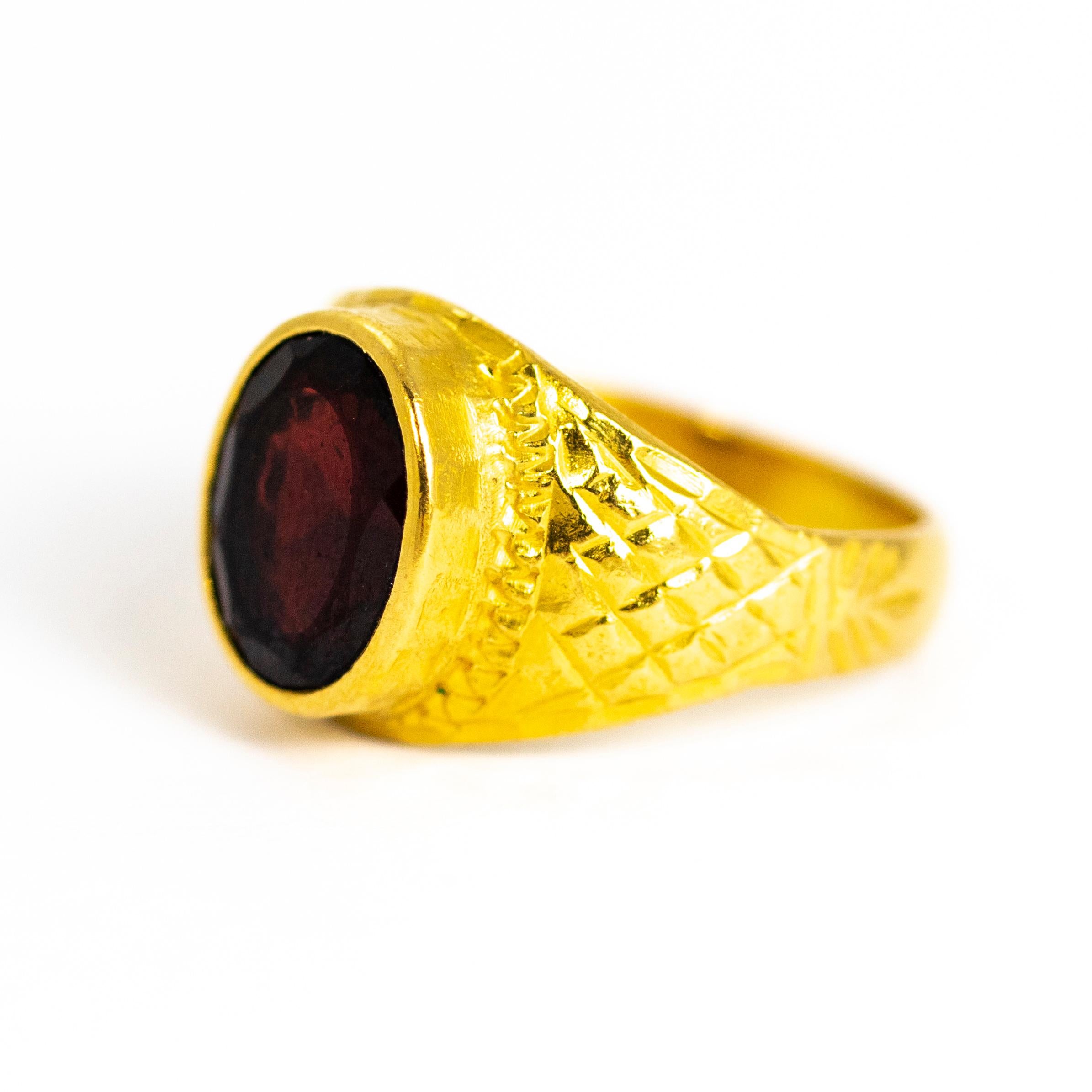 A wonderful vintage signet ring set with a superb flat-cut oval garnet. The stone is surrounded by fine detailing which extends onto the shoulders with a checked pattern. Modelled in 18 carat yellow gold

Stone Width: 3.50mm

Stone Height: