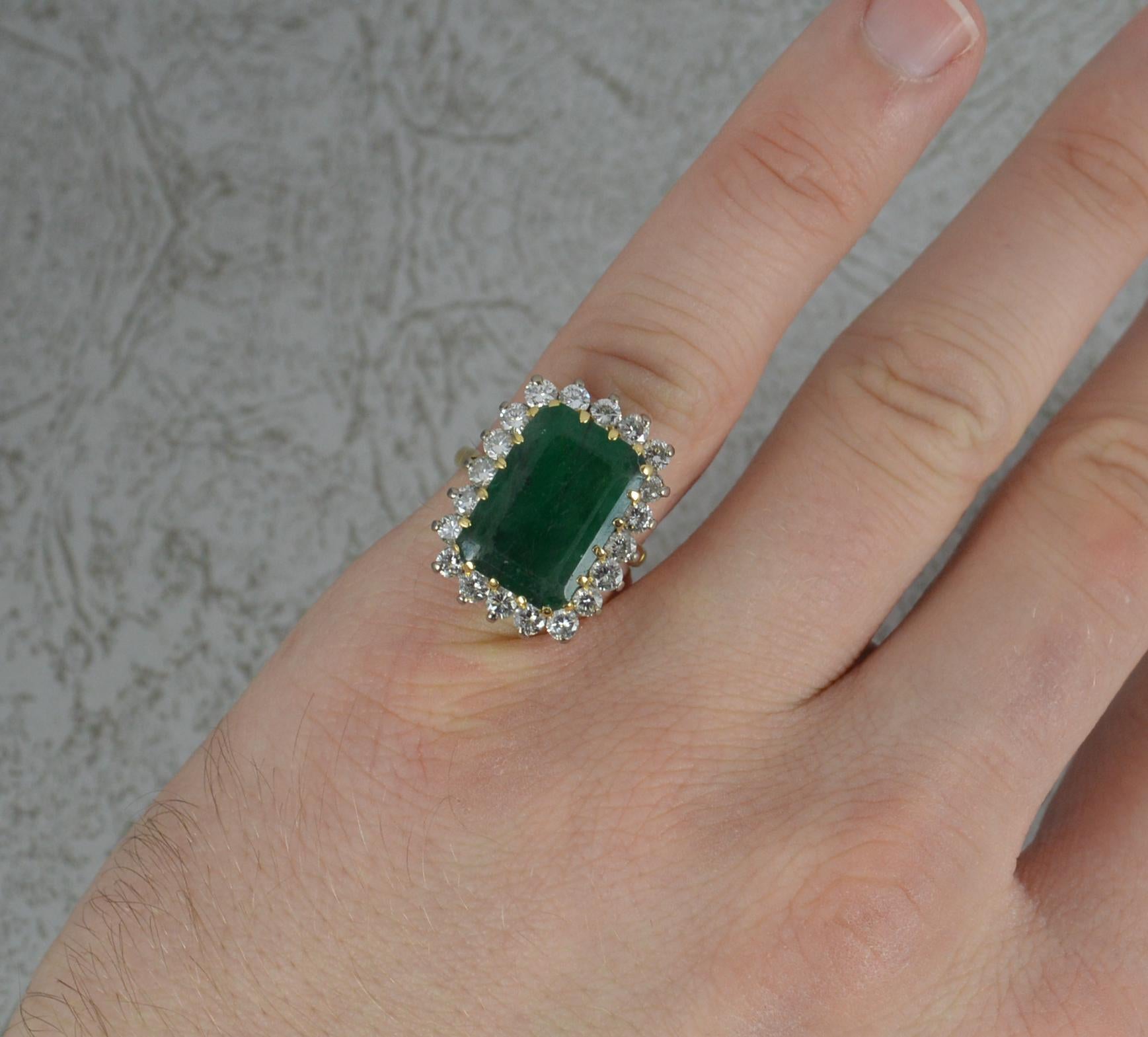 A superb Emerald and Diamond cluster ring.
Modelled in an 18ct yellow gold with a white gold head setting.
Designed with an emerald cut emerald to centre. 10.1mm x 14.6mm approx 6cts. Surrounding are twenty natural round brilliant cut diamonds. Each