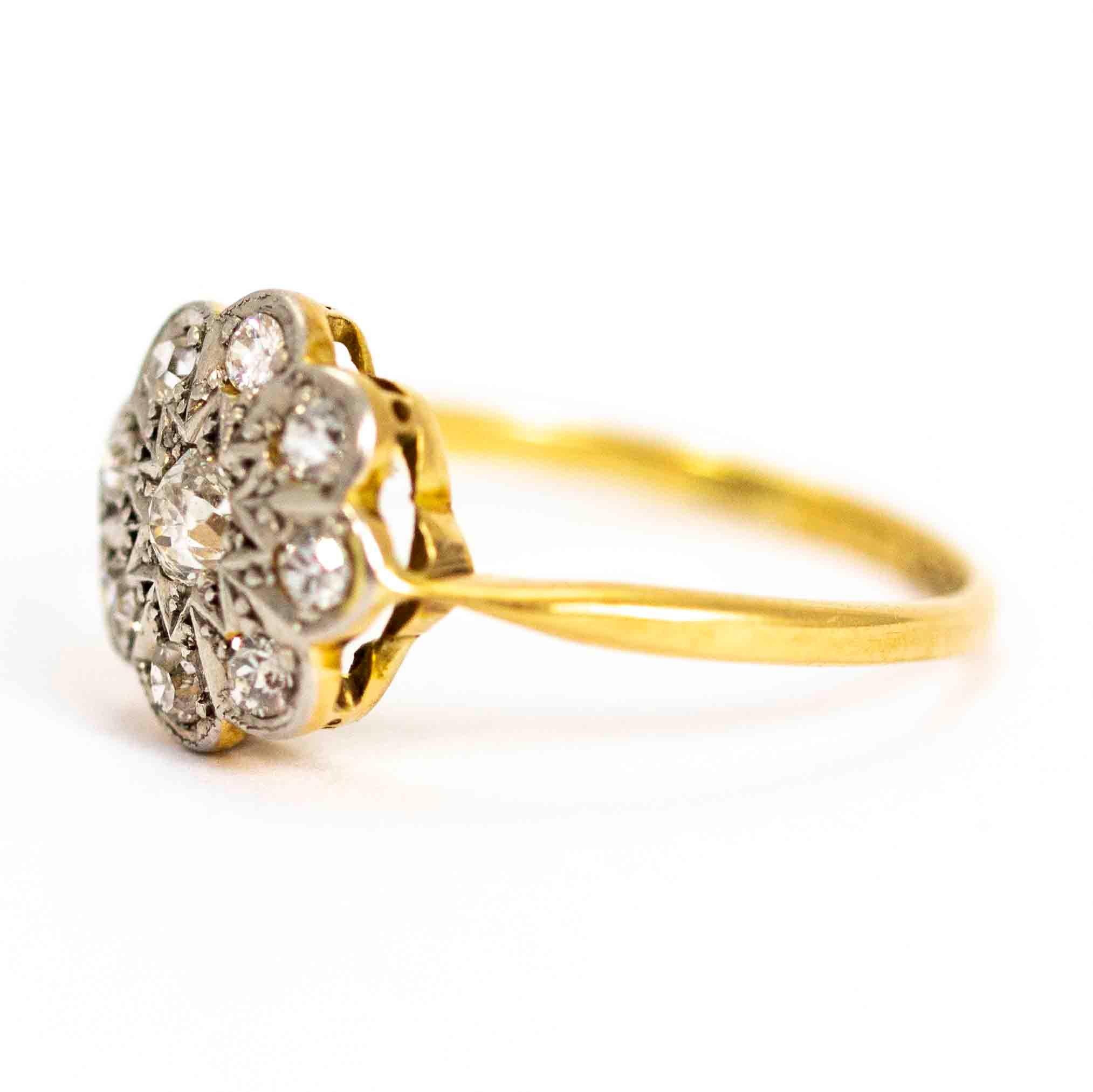 An exquisite vintage cluster ring set with nine stunning old mine cut white diamonds. The central stone measures approximately 10 points and  has a brilliant height. The diamonds in the surrounding halo measure approximately 8 points each. Total