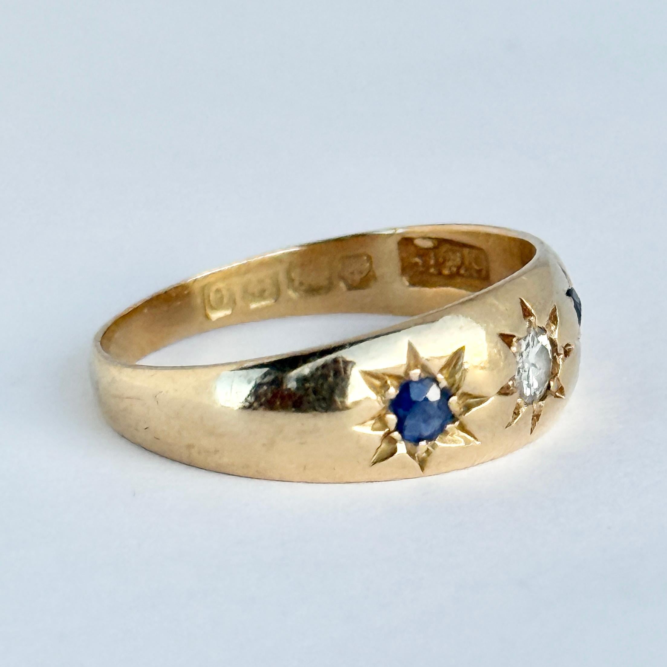 Questo anello contiene due zaffiri blu scuro e un diamante. Il diamante misura 15 carati e gli zaffiri 8 carati ciascuno. Questi sono impostati nelle impostazioni delle stelle. Completamente marcato Birmingham 1938. 

Misura dell'anello: O o 7 1/4