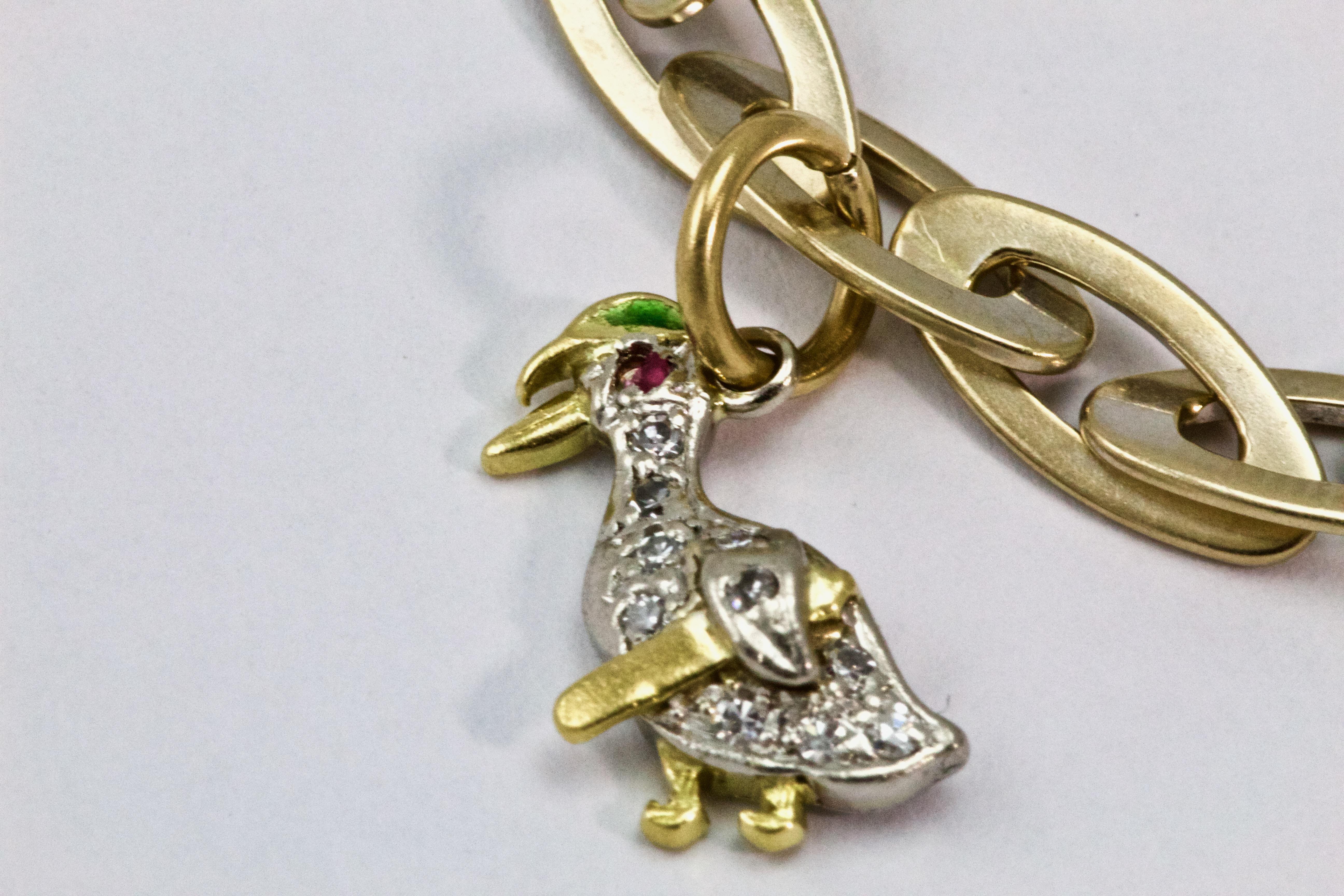 An absolutely stunning 18k gold bracelet with 3 Diamond charms. Firstly a duck with pave set diamonds throughout and a ruby accented eye, followed by a pave set diamond heart and finally a three dimensional white enamel rose with a central rose cut