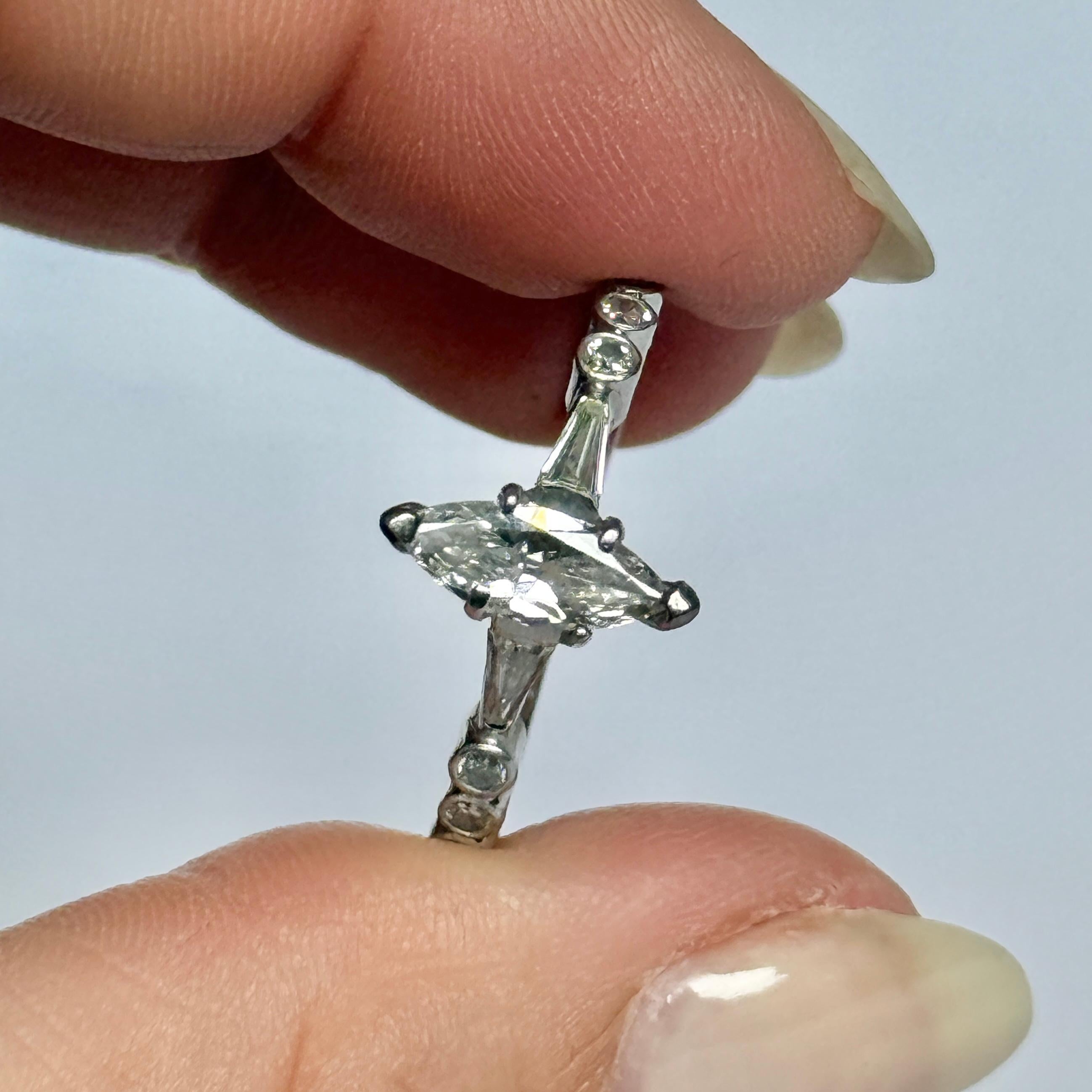 Questo splendido anello con diamante a forma di marquise è stato realizzato nel 1940 circa. Il diamante centrale brillante con taglio a marquise pesa 1,05 carati ed è affiancato con eleganza da diamanti a baguette affusolati. Modello in oro bianco