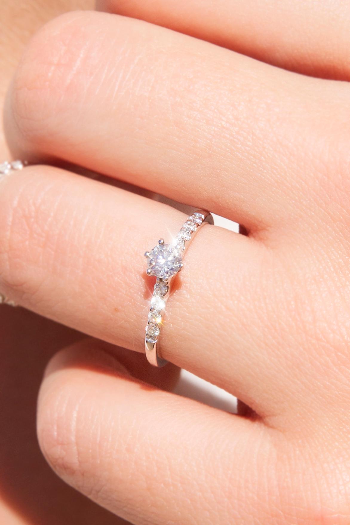 Forged in 18 carat gold, this elegant vintage ring features a lovely yellowish round brilliant diamond shimmering above graceful shoulders bead set with eight smaller round brilliant cut diamonds gleaming in unison. We have named her The Katelyn