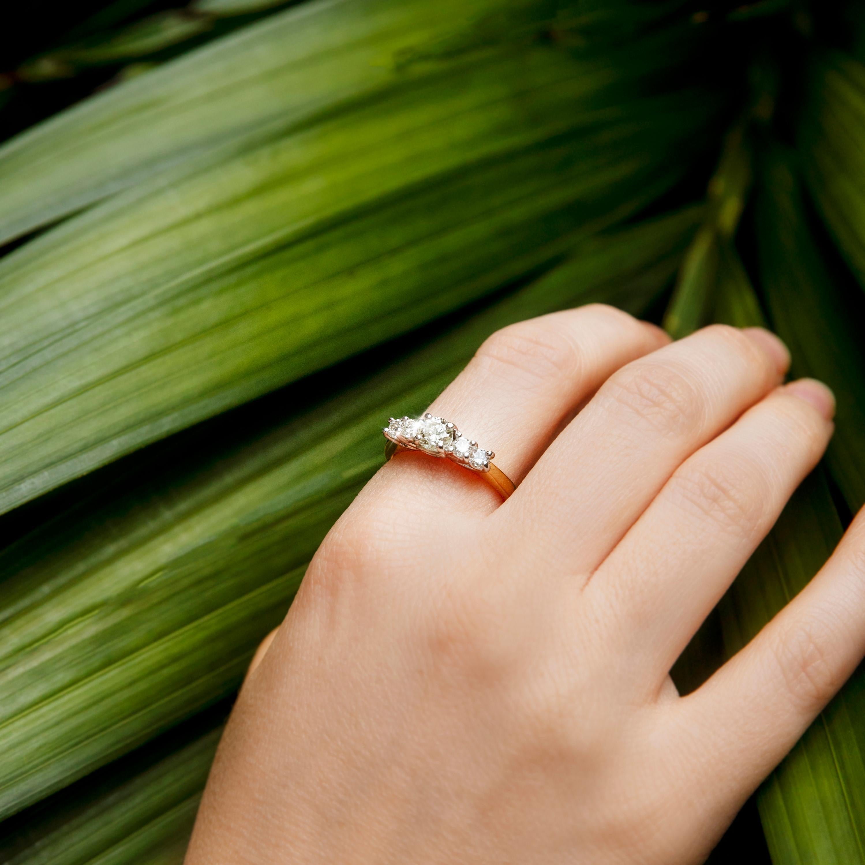 Dieser hübsche Vintage-Ring ist aus 18 Karat Gelbgold geschmiedet und zeigt fünf schimmernde runde Brillanten in einer Weißgold-Fassung im Spalierstil auf der Vorderseite des Rings. Ihr Name ist The Lilith Ring. Sie ist ein wundervoller Ring für