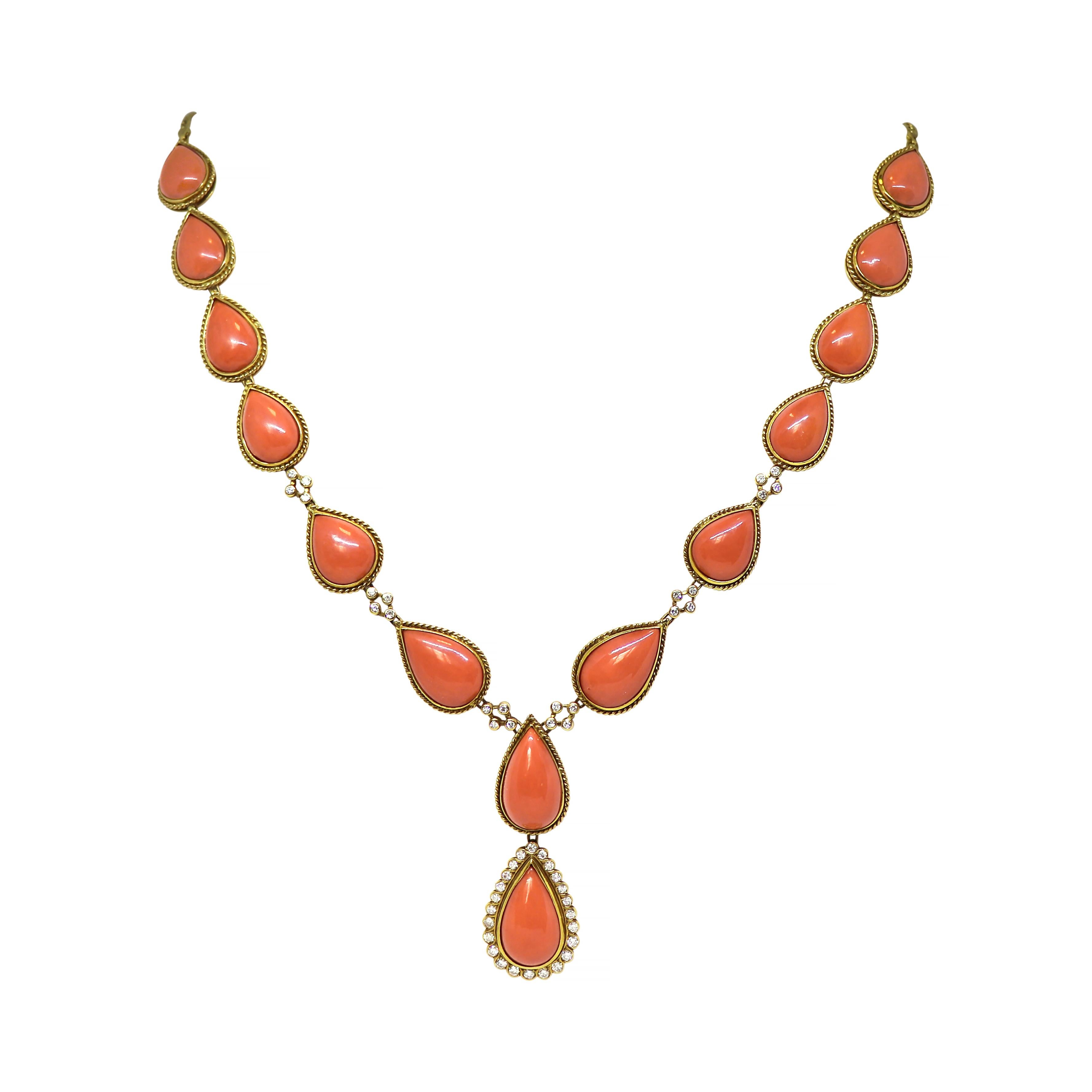 This handmade vintage necklace is made up of 14 pear shaped coral sections rubover set in 18 carat yellow gold with a fine rope design, connected to a solid flat curb chain. The lower half of the necklace is beautifully designed with 4 rubover set