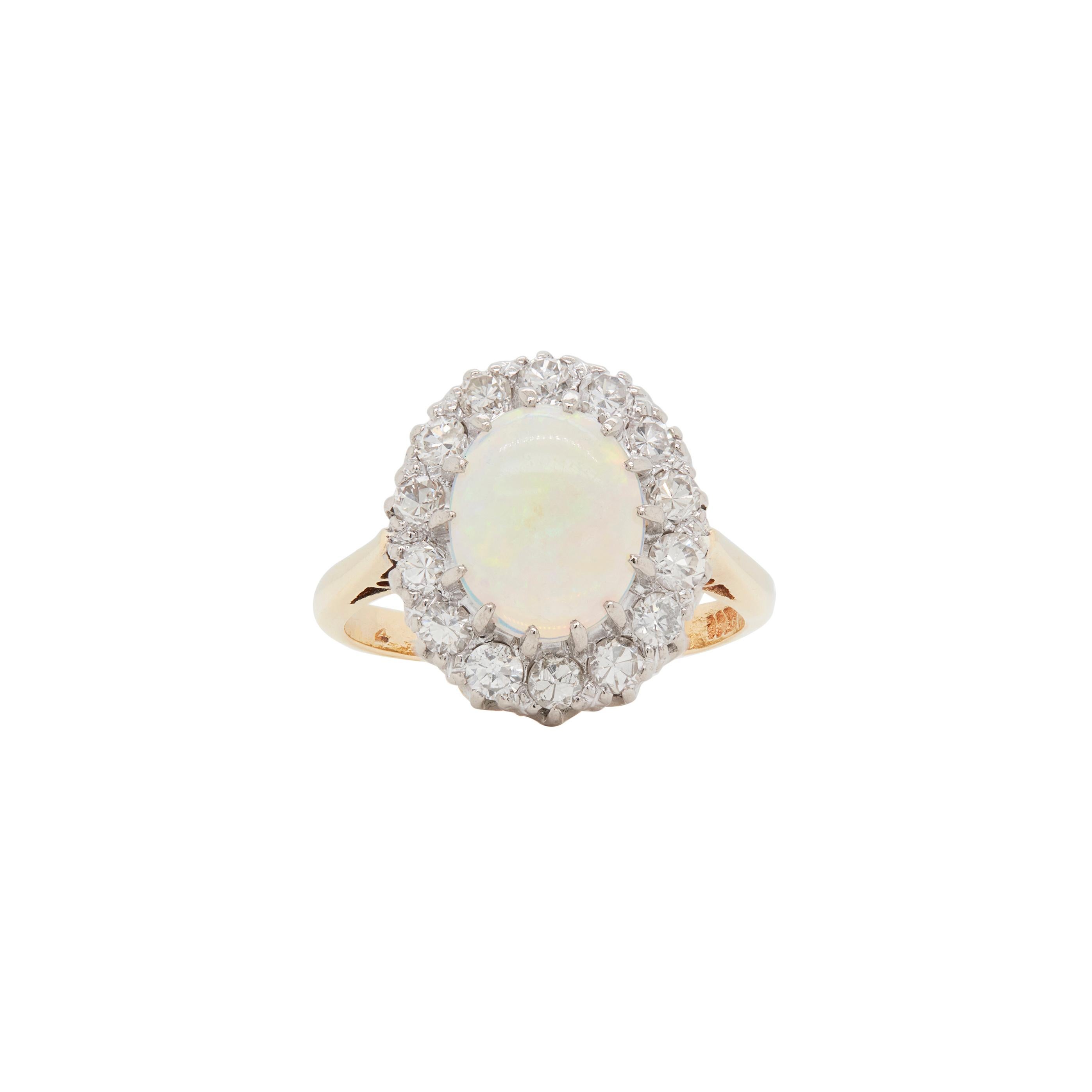 This exquisite opal and diamond cluster ring dates to the 1950s or 1960s and is simply sublime.

The opal, measuring approximately 8mm by 10mm exhibits a truly stunning play of colour, with blue, green and red all visible. It's one of the most
