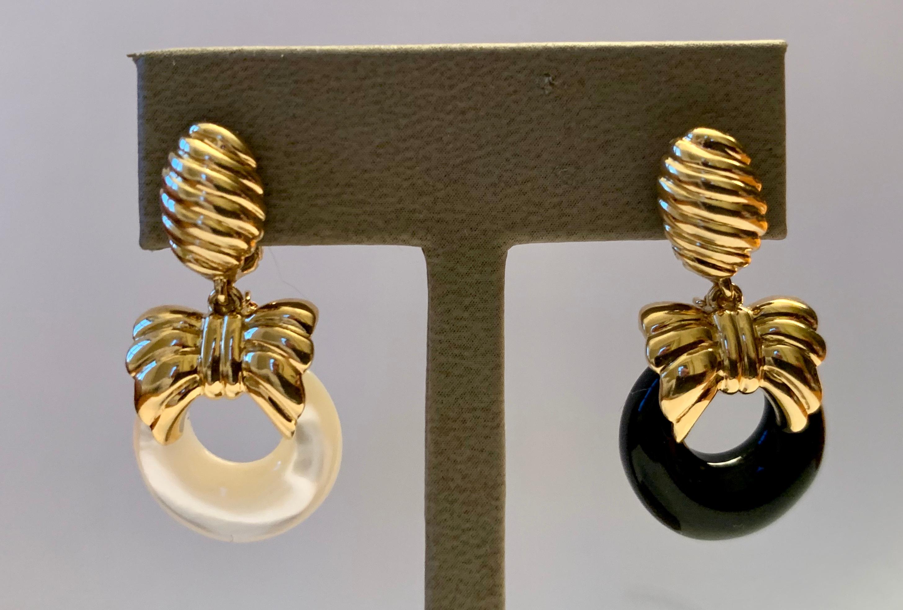 An intelligent and timeless chameleon design from Van Cleef & Arpels that features interchangeable door knocker earrings in 18 K yellow Gold with bow tie motives. Featuring hoops of  black onyx, ebony (wood) and mother of pearl.Signed VCA and