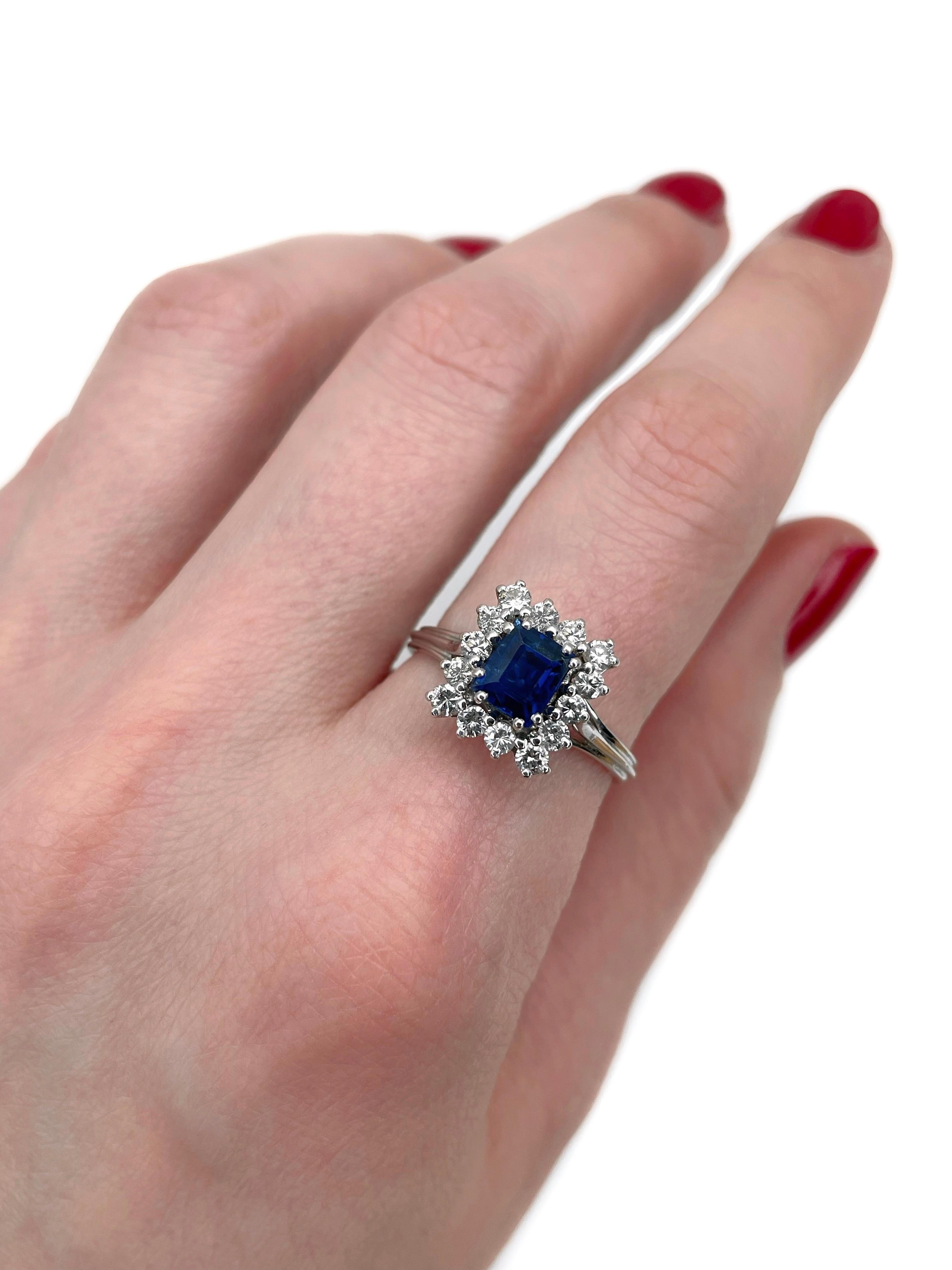 This is a vintage cluster ring crafted in 18K white gold. Circa 1980. 

The piece features:
- 1 sapphire (rectangular step cut, 1.00ct, B 6/4, SI)
- 14 diamonds (round brilliant cut, TW 0.55ct, RW-W, VS-SI)

Weight: 4.11g
Size: 18.25 (US
