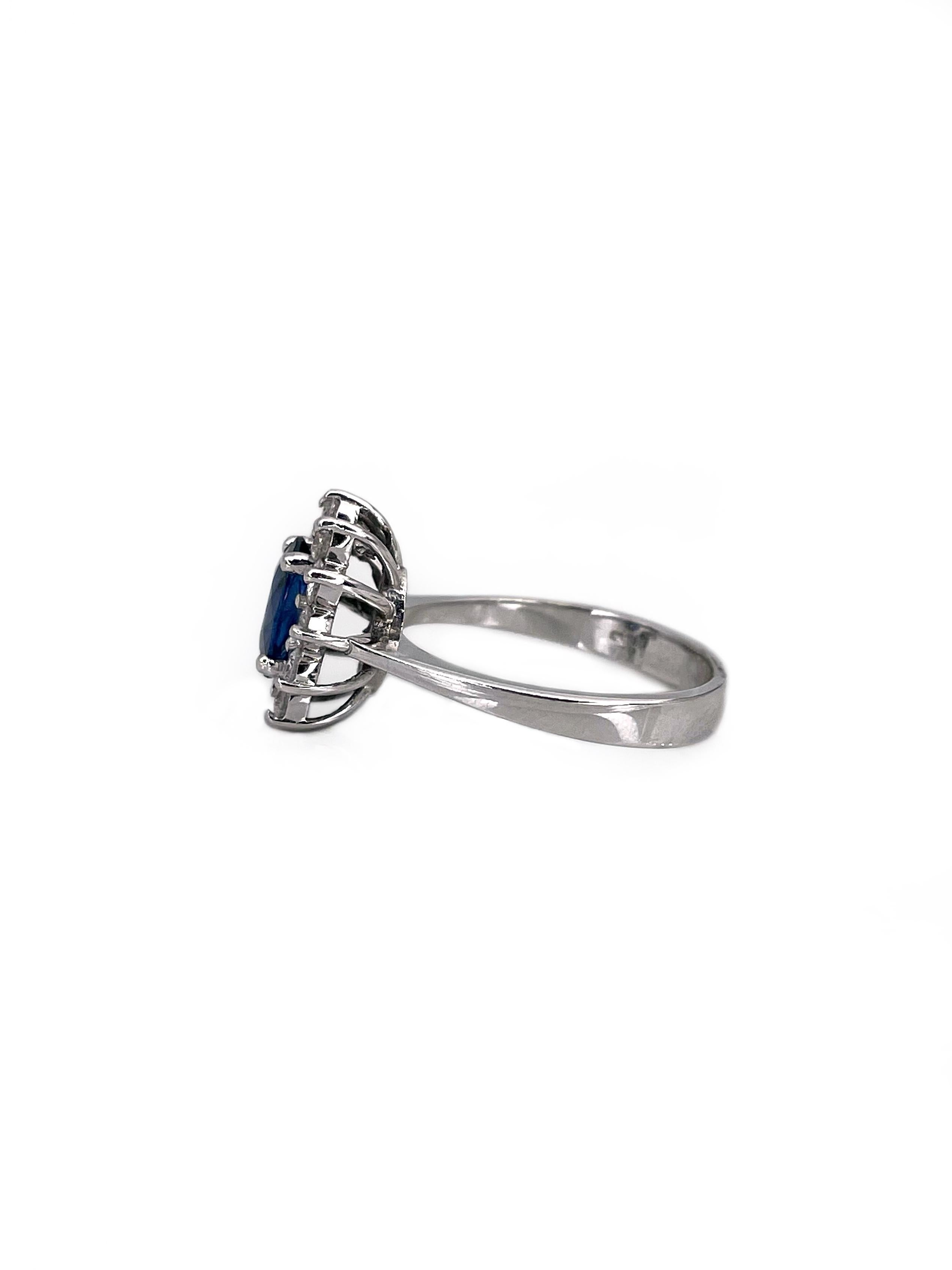 This is a beautiful vintage engagement cluster ring crafted in 18K white gold. The piece features 1.50ct oval blue sapphire (H, U). The gem is surrounded by 12 brilliant cut diamonds (TW 0.60ct, RW, VS-P1). 

Weight: 4.40g
Size: 17 (US