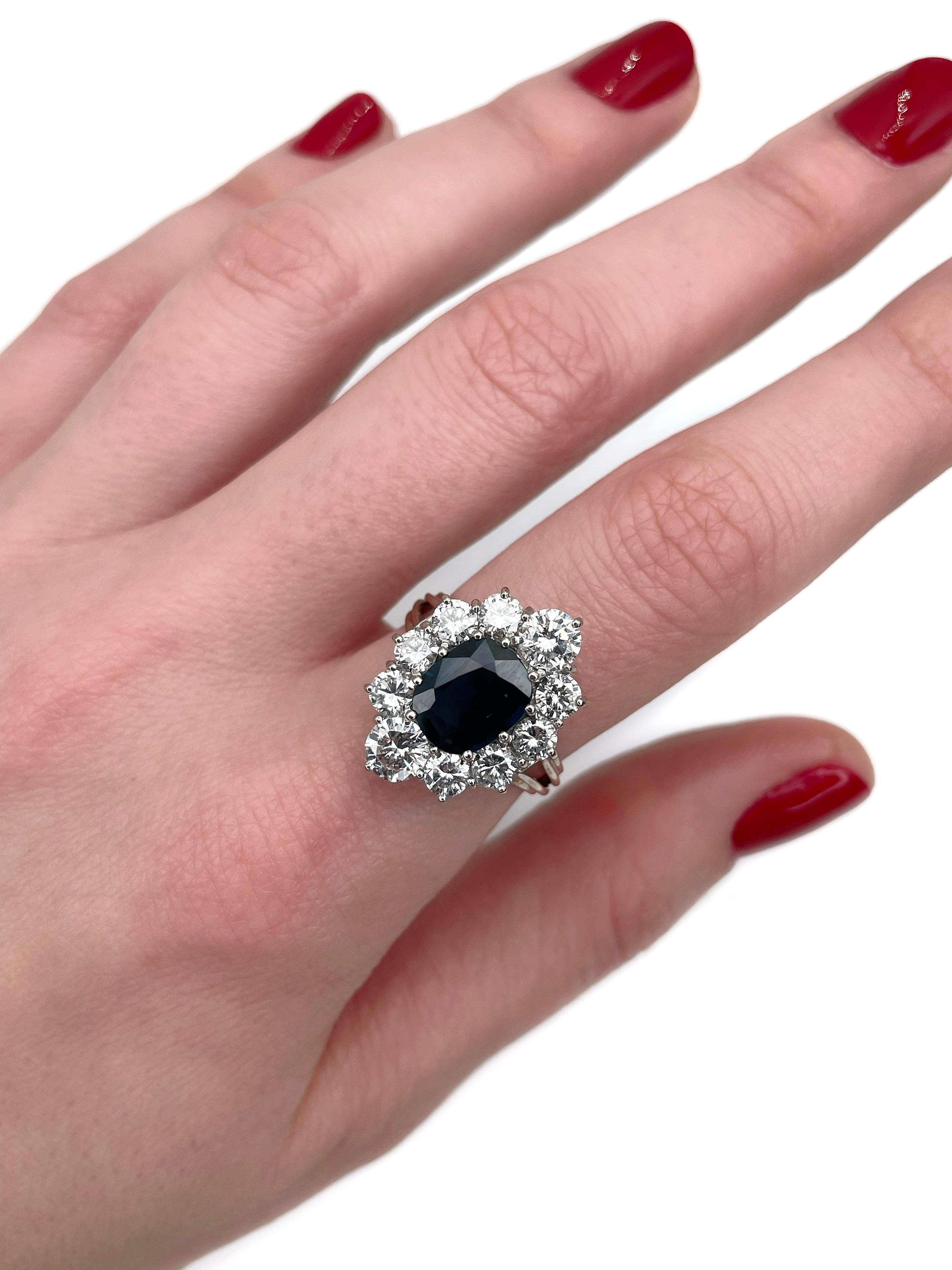 This is a vintage cluster ring crafted in 18K gold. Circa 1980. 

The piece features:
- 1 sapphire (cushion cut, 1.90ct, B 8/3, VS)
- 10 diamonds (round brilliant cut, TW 2.50ct, RW-W, SI)

Weight: 6.12g
Size: 17.25 (US 6.75)

IMPORTANT: please ask