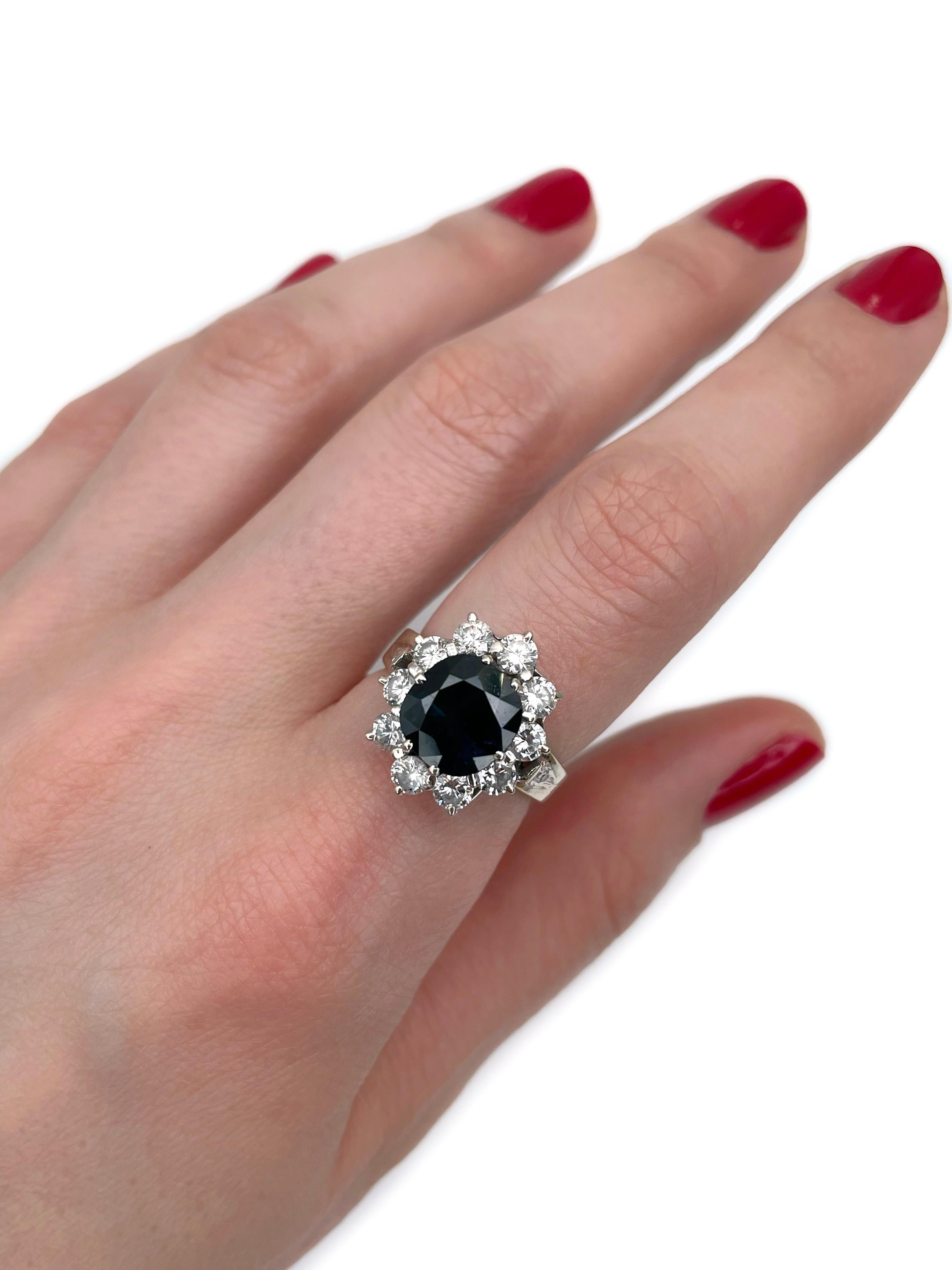 This is a vintage ring crafted in 18K gold. Circa 1980. 

The piece features:
- 1 sapphire (cushion cut, 3.00ct, B 8/4, SI)
- 10 diamonds (round brilliant cut, TW 1.25ct, RW+/W, VS-SI)

Weight: 6.81g
Size: 16.25 (US 5.75)

IMPORTANT: please ask