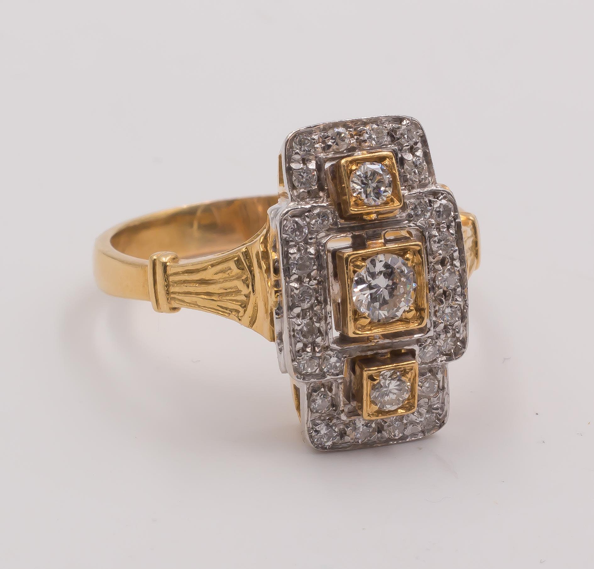 This vintage ring is decorated with three central round cut diamonds, set in a yellow gold mount; a set of round cut diamonds studs the entire head of the ring, crafted in both yellow and white gold. The ring is set with a beautiful opework, while