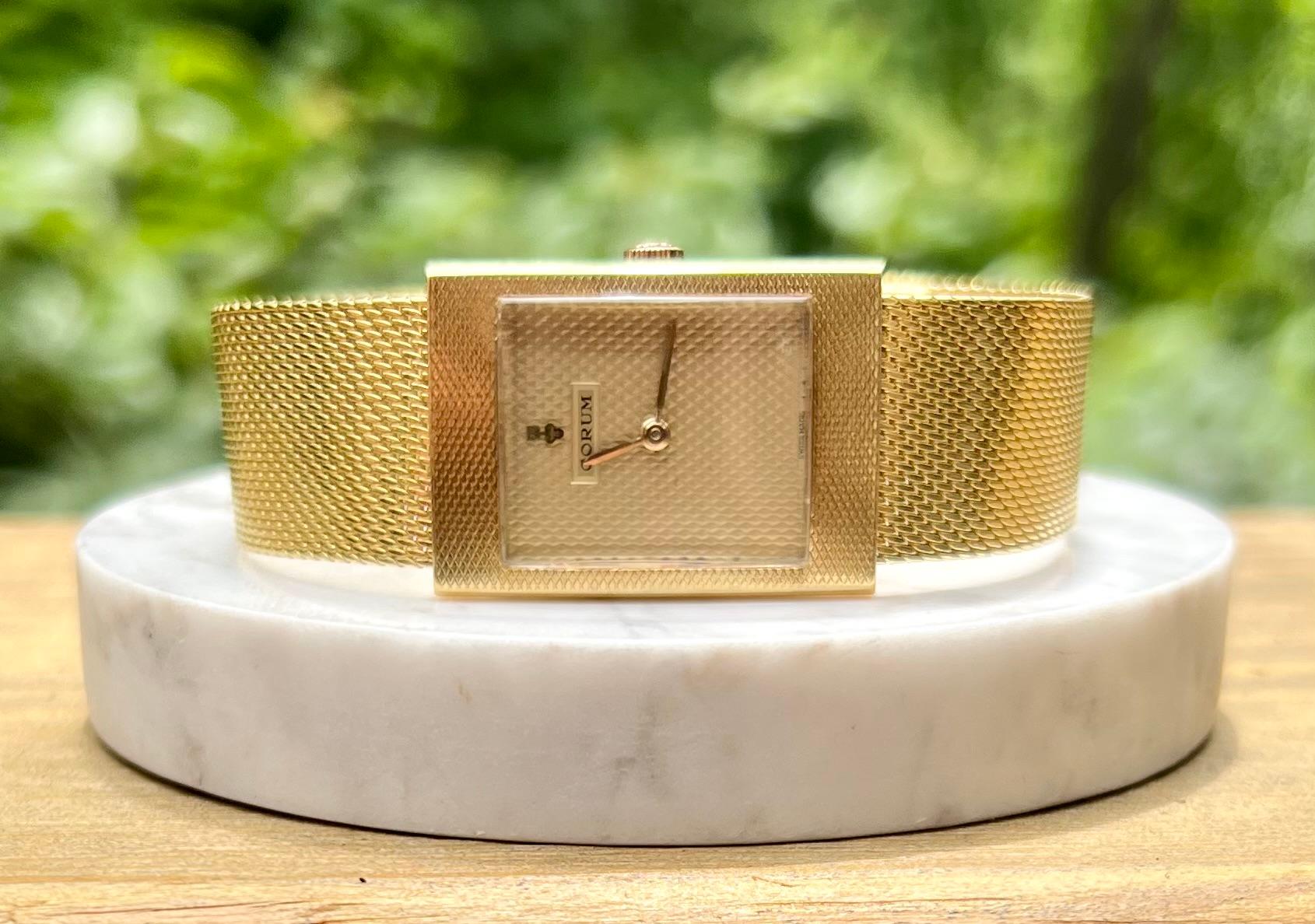One 18 karat yellow gold vintage Swiss made Corum ladies watch with adjustable mesh band.  The dial case measures 30.52mm x 21.85mm.  