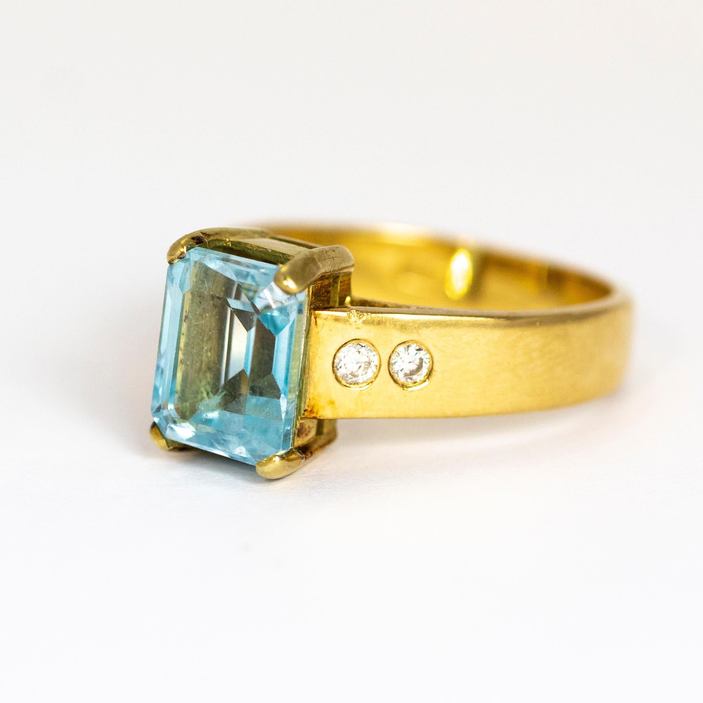 This superb vintage ring is set with a beautiful emerald cut aquamarine in a four claw setting. The shoulders of the chunky band are each set with two round white diamonds. Modelled in 18 karat yellow gold

Ring Size: UK R 1/2, US 9

Stone Height: