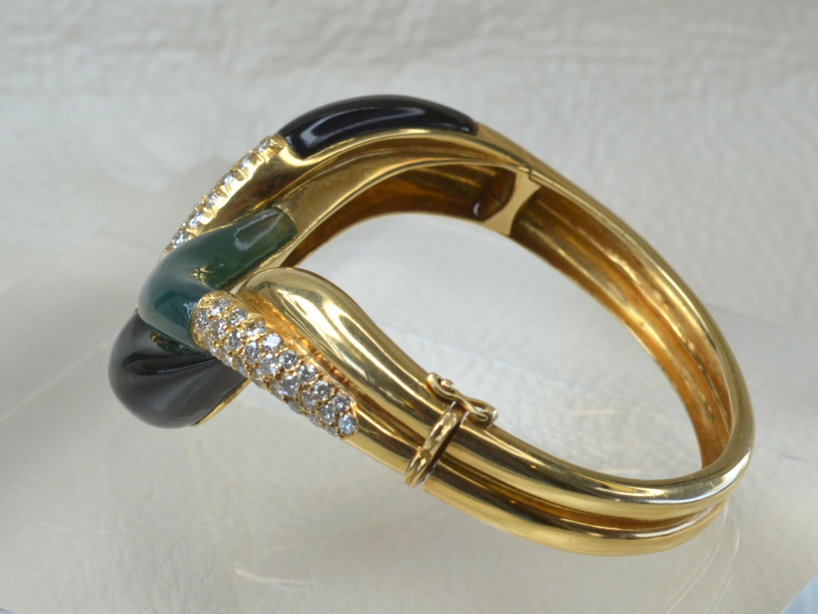 Das ineinander greifende Design dieses Armbands wird durch zwei große, glatte Stücke aus Blank Onyx und ein glatt geschliffenes Stück aus waldgrüner Jade vervollständigt. Insgesamt 20 weiße Diamanten unterstreichen die tiefen Farben der Steine.