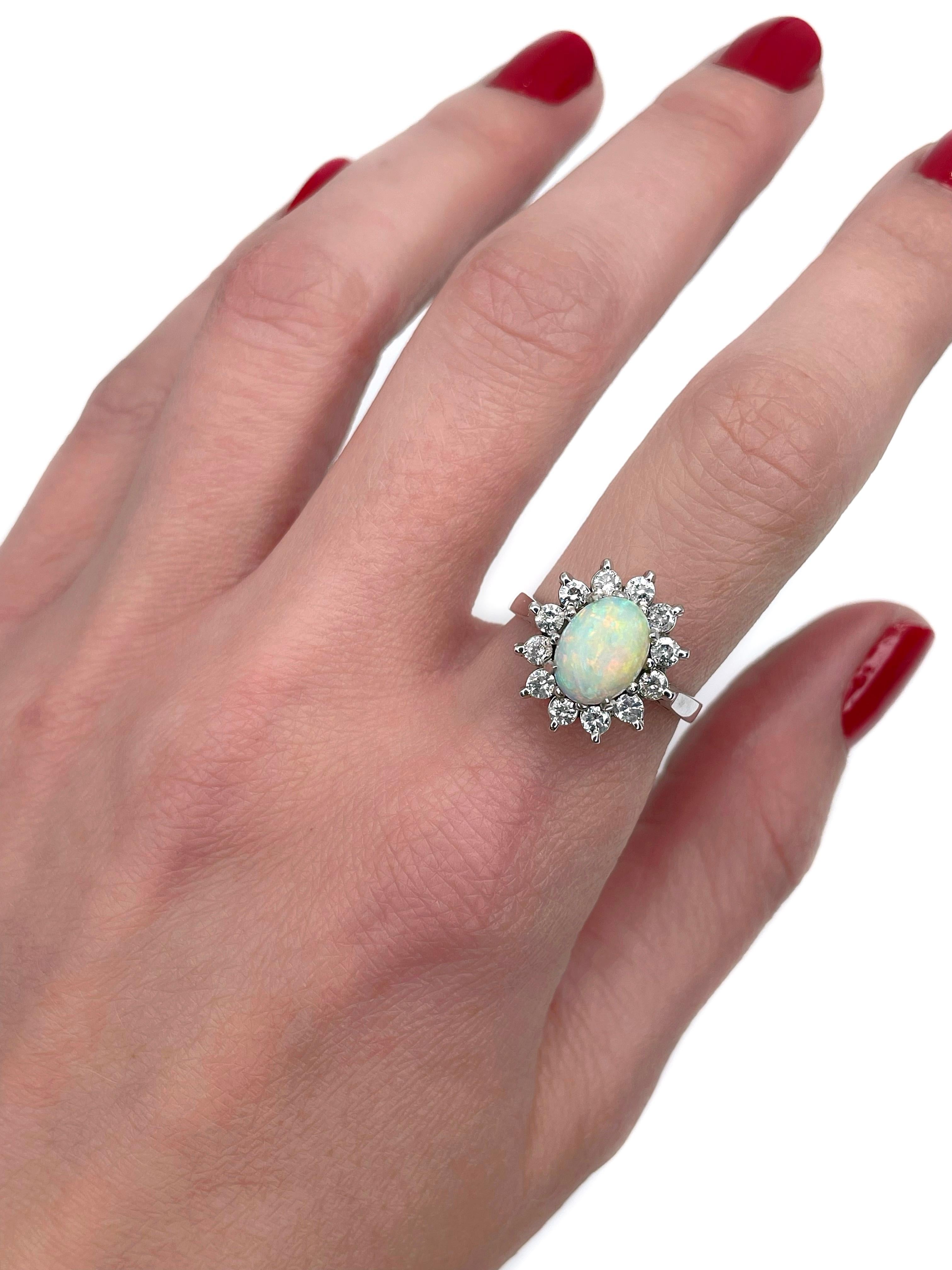 This is a vintage cluster ring crafted in 18K white gold. Circa 1980. 

It features:
- 1 opal, oval cabochon cut
- 12 diamonds, brilliant cut, TW 0.50ct, RW-W, P2

Weight: 5.18g
Size: 17 (US 6.75)

IMPORTANT: please ask about the possibility to