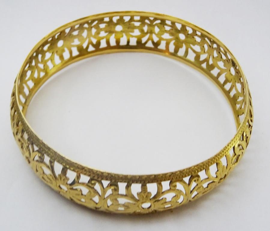 This vintage bangle is a true piece of artistry, crafted from 18 karat gold and featuring an intricate openwork design.
The gold is engraved with delicate details, adding to its unique and timeless charm.
It is a beautiful accessory to add to any