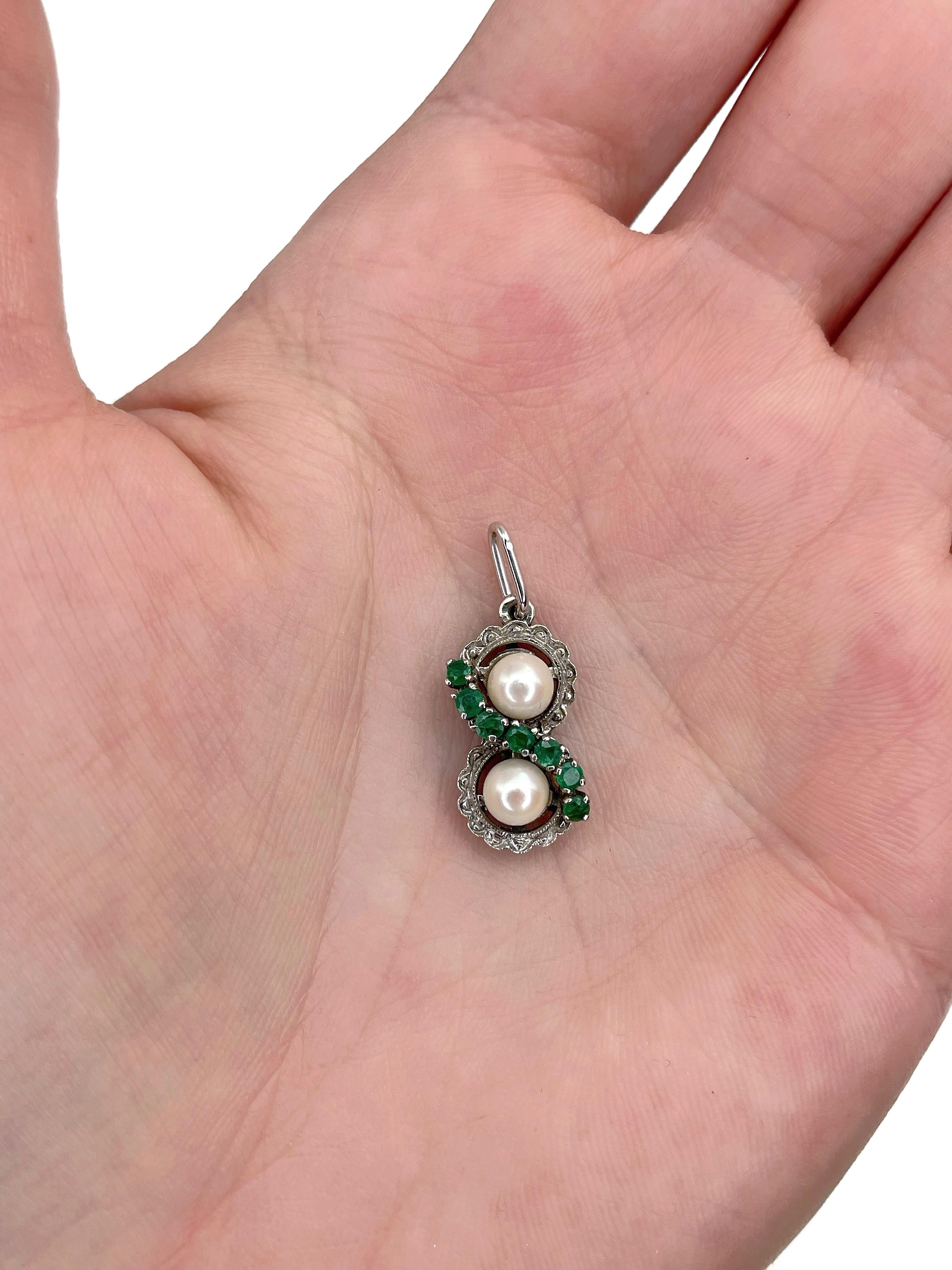 This is a vintage infinity pendant crafted in 18K white gold. Circa 1970.

The piece features: 
- 2 pearls, cultured, ~5mm
- 7 emeralds, round cut, TW 0.23ct, vslbG 5/4, P1-P2

Weight: 2.31g
Size: 2.5x1cm

IMPORTANT: As a buyer, you are fully