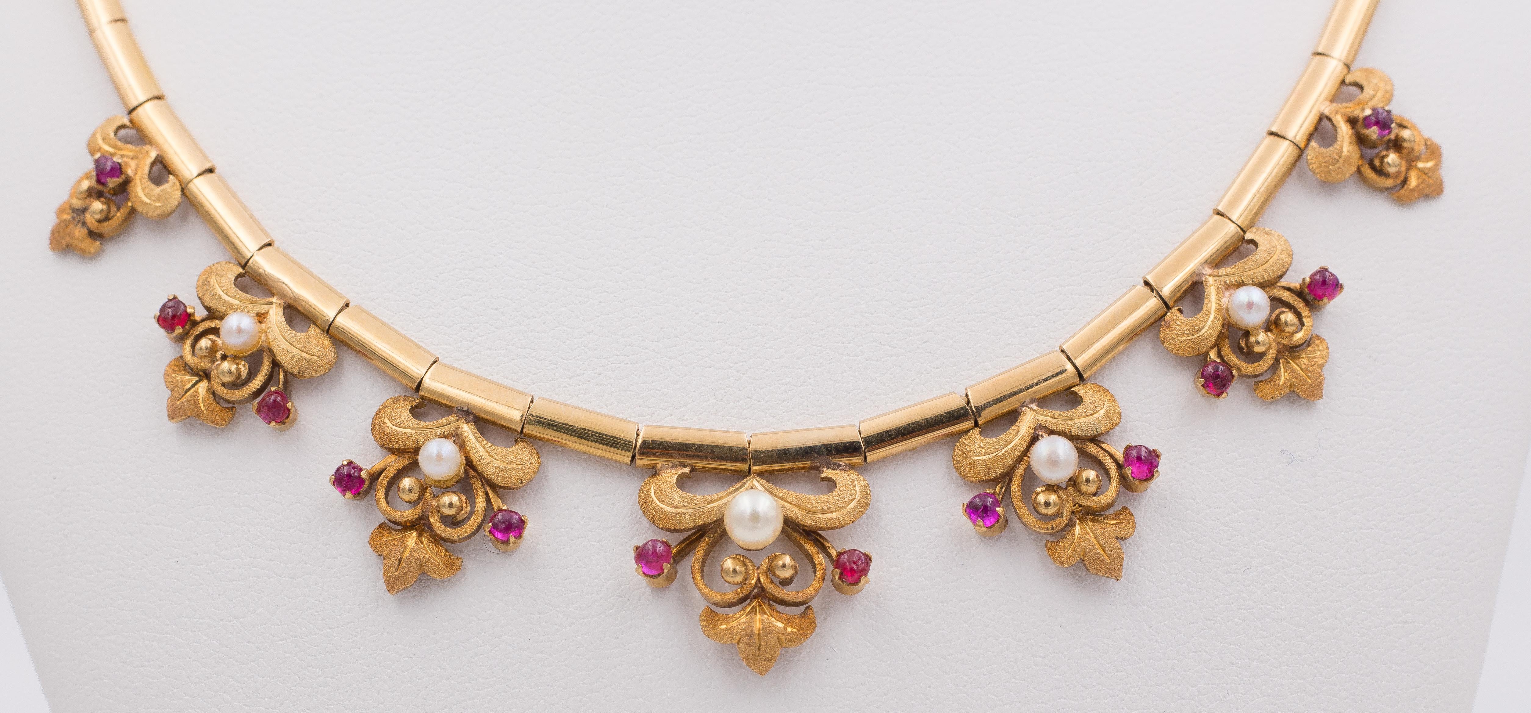 A very elegant vintage necklace: dating from the 1960s, it is set with some beautiful pendant floral and geometrical decorations, ornamented with rubies and white beads. 
The necklace is crafted in 18K gold throughout. 

MATERIALS
18K gold, rubies