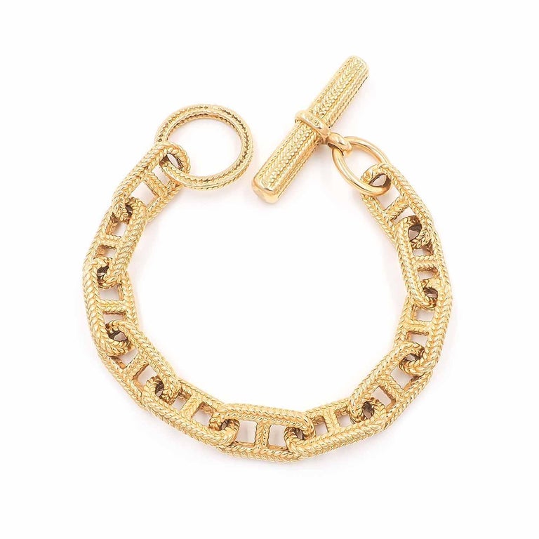 Super Chic Vintage Anchor Link Gold Chain Bracelet composed of 18k yellow gold. With a rope-style texturing to the elongated oval links with vertical gold bars, often referred to as 'Chaine D'ancre'. With a dangling toggle at one end of the bracelet