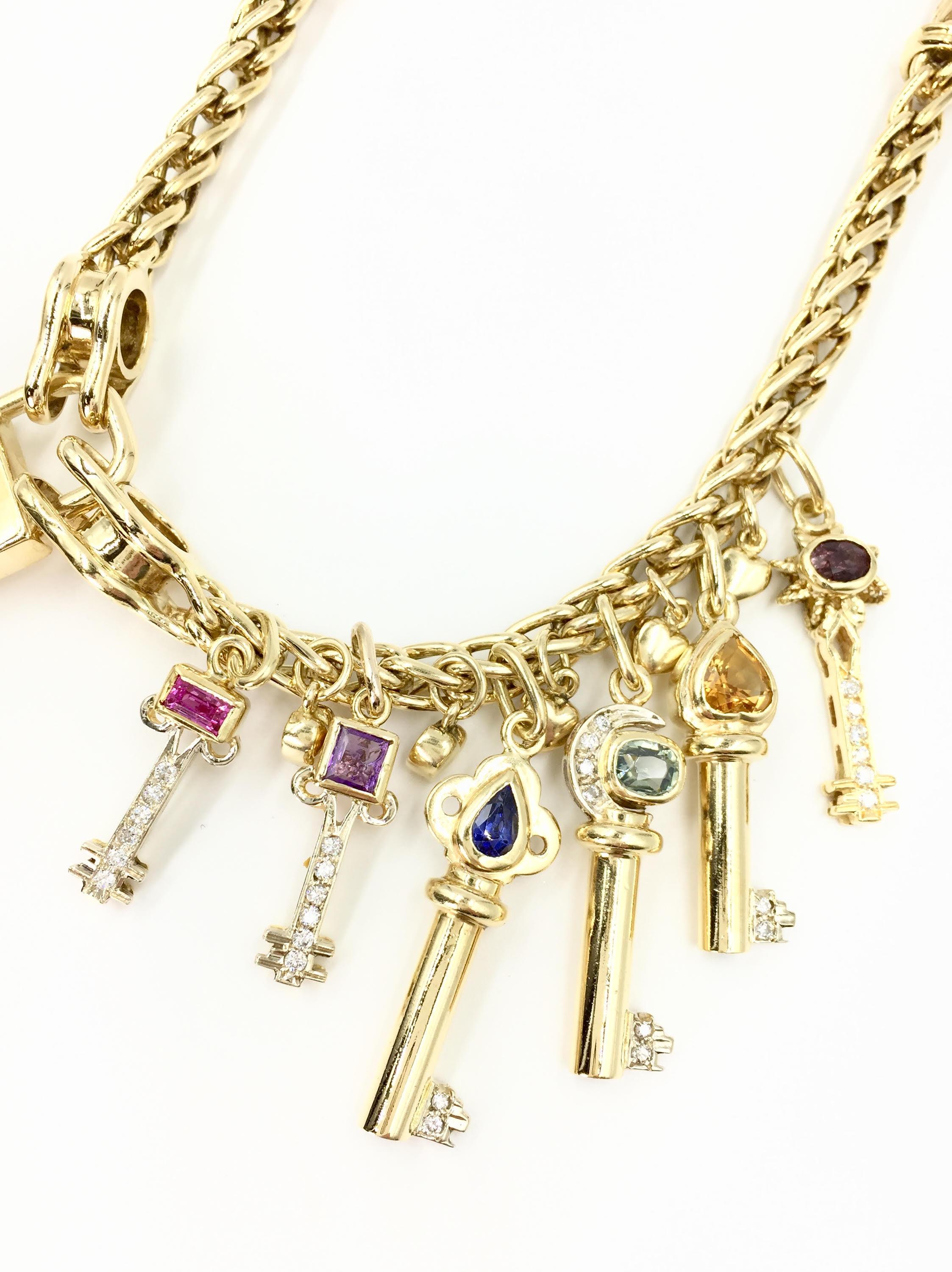 Heavy and substantial this vintage 18 karat yellow gold charm necklace features a golden padlock and 6 dangling diamond and semi-precious gemstone keys. Each key has a different gemstone set at the top including light and dark blue topaz, amethyst,
