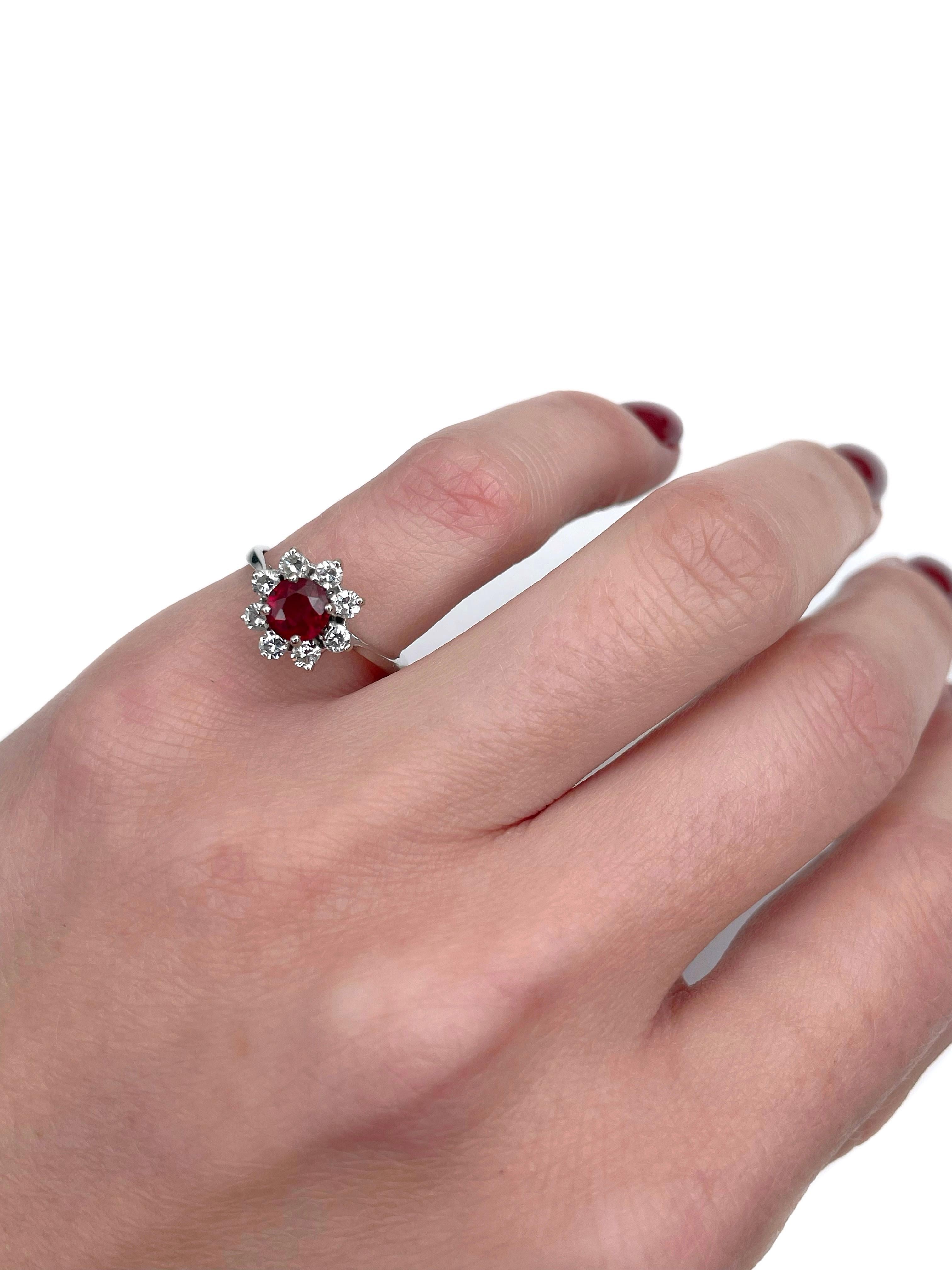 This is a vintage cluster ring crafted in 18K white gold. Circa 1990. 

The piece features:
- 1 ruby (round cut, 0.60ct, slpR 6/4, SI)
- 8 diamonds (round brilliant cut, TW 0.32ct, RW+/RW, VS-SI)

Weight: 2.45g
Size: 15.25 (US 4.5)

IMPORTANT: